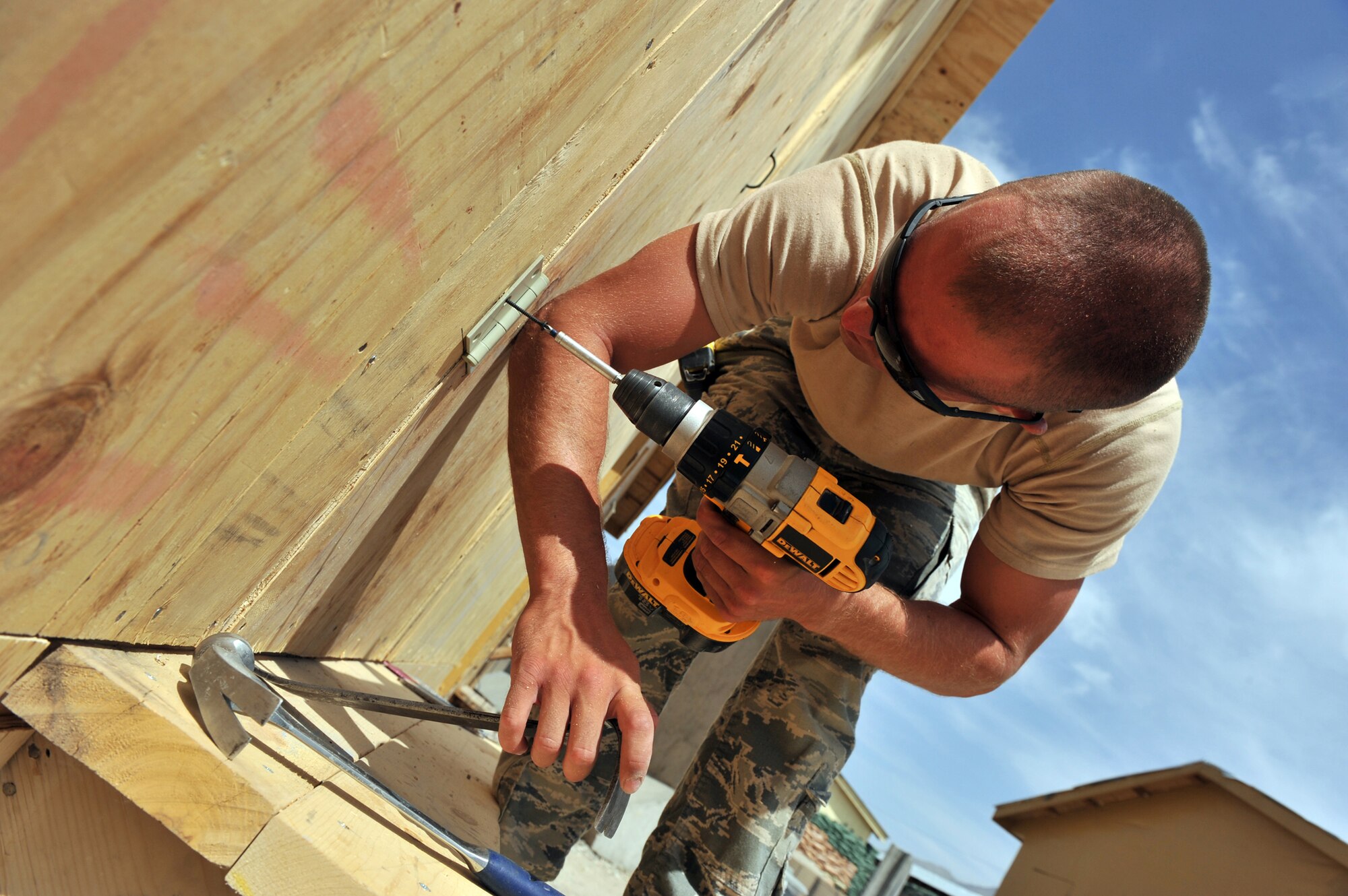 Airman 1st Class Tyler Saulsgiver installs a door on a newly built dining facility expansion May 23, 2011, at a combat outpost in Afghanistan. Airman Saulsgiver is a structural journeyman assigned to the 577th Expeditionary Prime Base Engineer Emergency Force Squadron. (U.S. Air Force photo/Senior Airman Sheila deVera) 