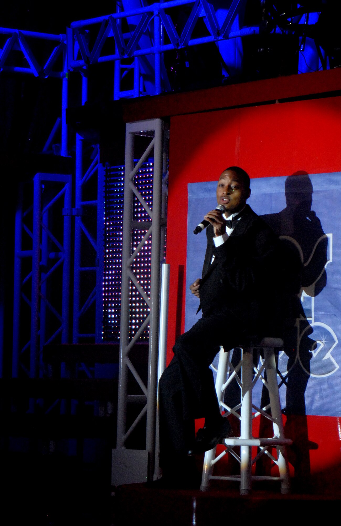 SAN ANGELO, Texas -- Staff Sgt. Derek Speights, Tops in Blue 2011 vocalist, sings in the spotlight for the crowd at the San Angelo Coliseum June 1 during the Rhythm Nation show. San Angelo was the third stop on their 2011 tour list, which includes a variety of stateside bases, Europe and even Asia. (U.S. Air Force photo/Airman 1st Class Michael Smith) 