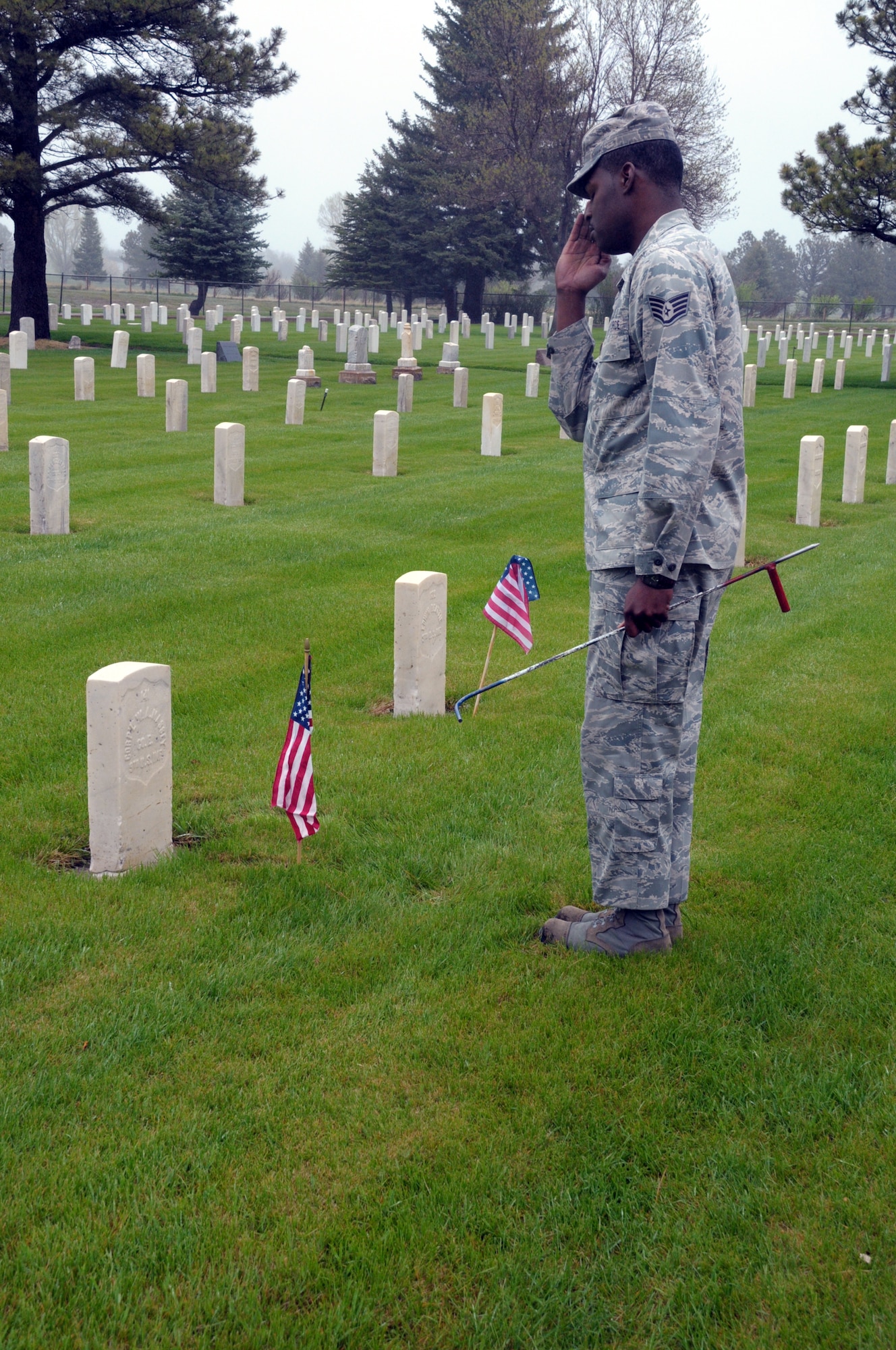 Staff Sgt. Fredrick Stewart, Honor Guard NCO-in-charge, salutes the grave of a veteran resting in the base cemetery at F. E. Warren May 29. (U.S. Air Force photo by Blaze Lipowski)