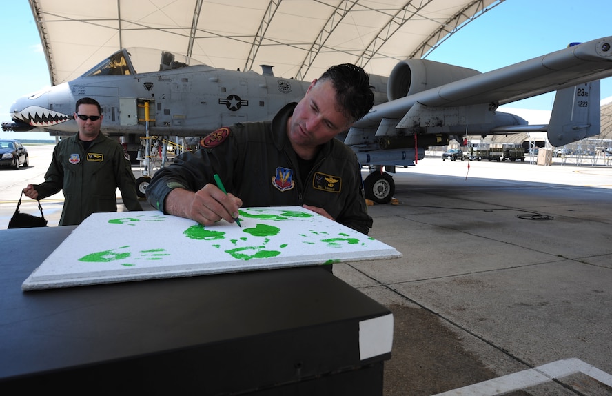 Col. William DeMaso, 23rd Wing vice commander, signs a ceiling tile with his footprints on it, at Moody Air Force Base, Ga. June 2. This is one of the many traditions of the 23rd Wing.  (U.S. Air Force photo/Senior Airman Stephanie Mancha)(RELEASED)