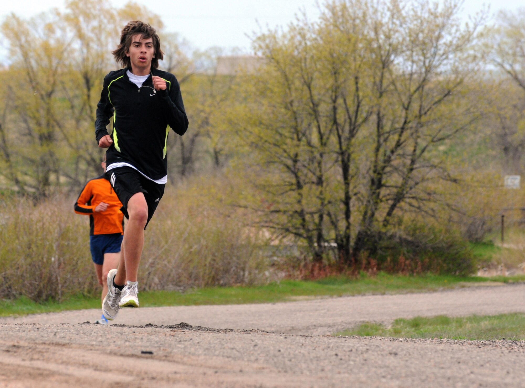 Josh Gonzales leads a 5k run at the half-way point May 24. Runners had to deal with a cold, 17 mph wind during the run, co-sponsored by the Health and Wellness Center and the chapel’s Airman Ministry Center. Gonzales finished the run second to Capt. Bryant Bevan, 90th Missile Wing. Alison Morrell, HAWC exercise physiologist, said there are plans to make the run a monthly event throughout the summer. (U.S. Air Force photo by R.J. Oriez)