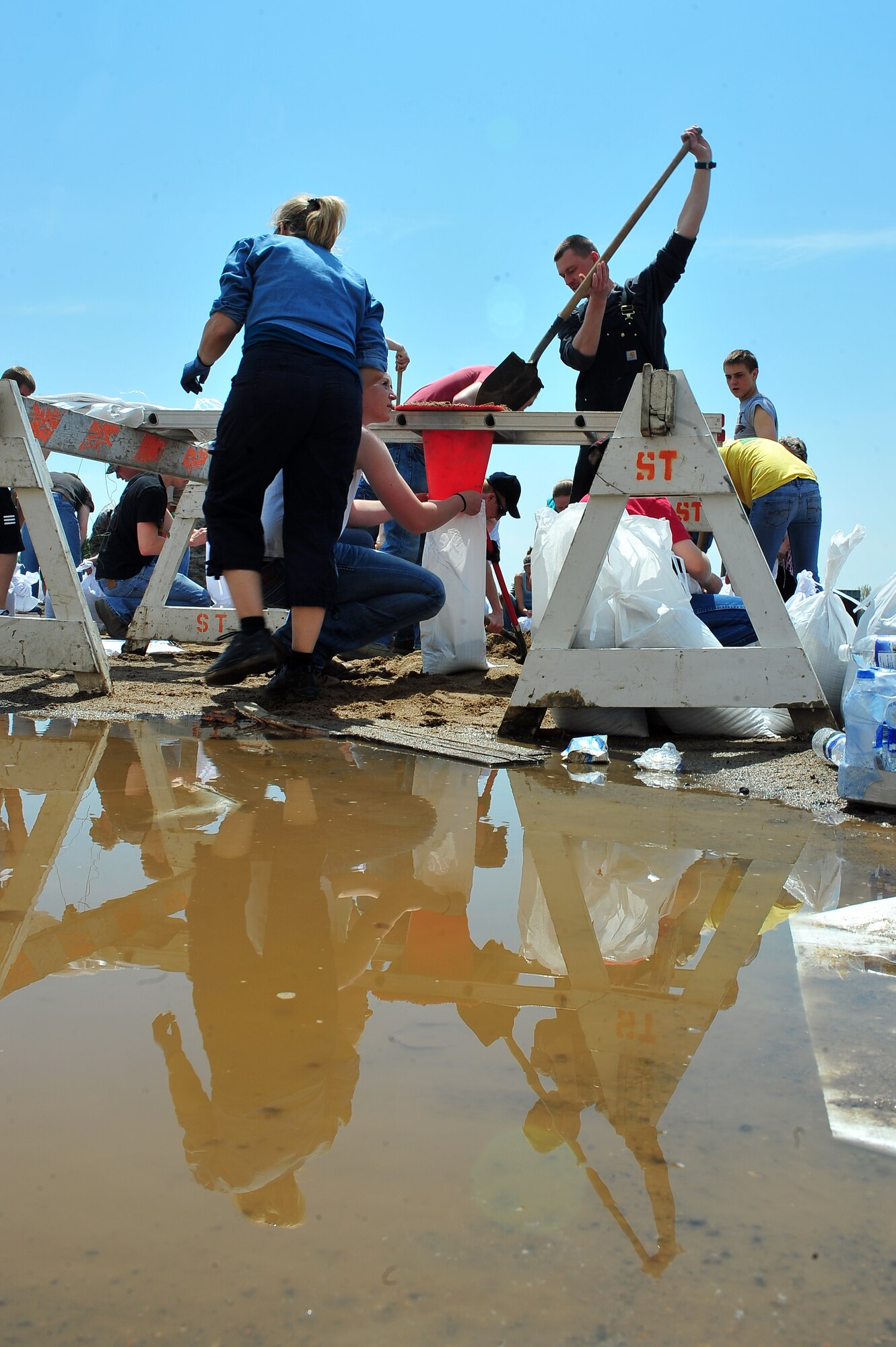 Airmen and local citizens work together to make sandbags at the Minot Public Works June 1, 2011, in Minot, N.D. In preparation for possible flooding, the city of Minot, with assistance from Airmen from Minot Air Force Base, North Dakota National Guard as well as many other organizations, are setting up secondary dikes along the river. The Souris River threatens to break the levies already in place, thousands of Minot citizens, including military members, their families and DOD civilians, have been forced to evacuate the area. (U.S. Air Force photo/Senior Airman Jesse Lopez)