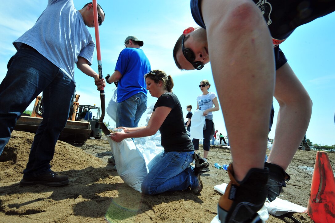 Airmen and local citizens work together to make sandbags at the Minot Public Works June 1, 2011, in Minot, N.D. In preparation for possible flooding, the city of Minot, with assistance from Airmen from Minot Air Force Base, North Dakota National Guard as well as many other organizations, are setting up secondary dikes along the river. The Souris River threatens to break the levies already in place, thousands of Minot citizens, including military members, their families and DOD civilians, have been forced to evacuate the area. (U.S. Air Force photo/Senior Airman Jesse Lopez)