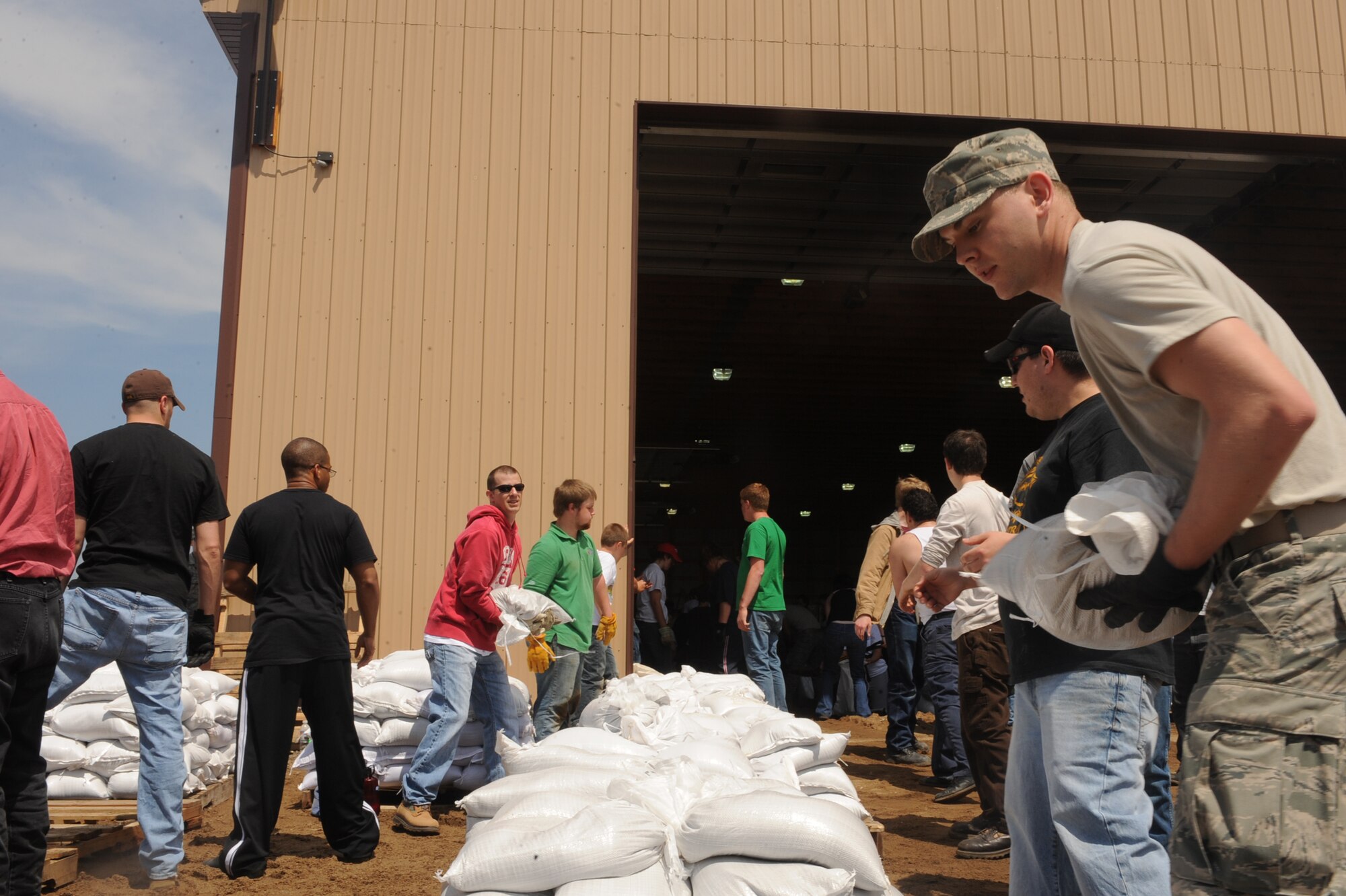 Airmen and local citizens work together to prepare sandbags for the incoming floods June 1, 2011, in Minot, N.D. In preparation for possible flooding, the city of Minot, with assistance from Airmen from Minot Air Force Base, North Dakota National Guard as well as many other organizations, are setting up secondary dikes along the river. The Souris River threatens to break the levies already in place, thousands of Minot citizens, including military members, their families and DOD civilians, have been forced to evacuate the area. (U.S. Air Force photo/Airman 1st Class Aaron-Forrest Wainwright)