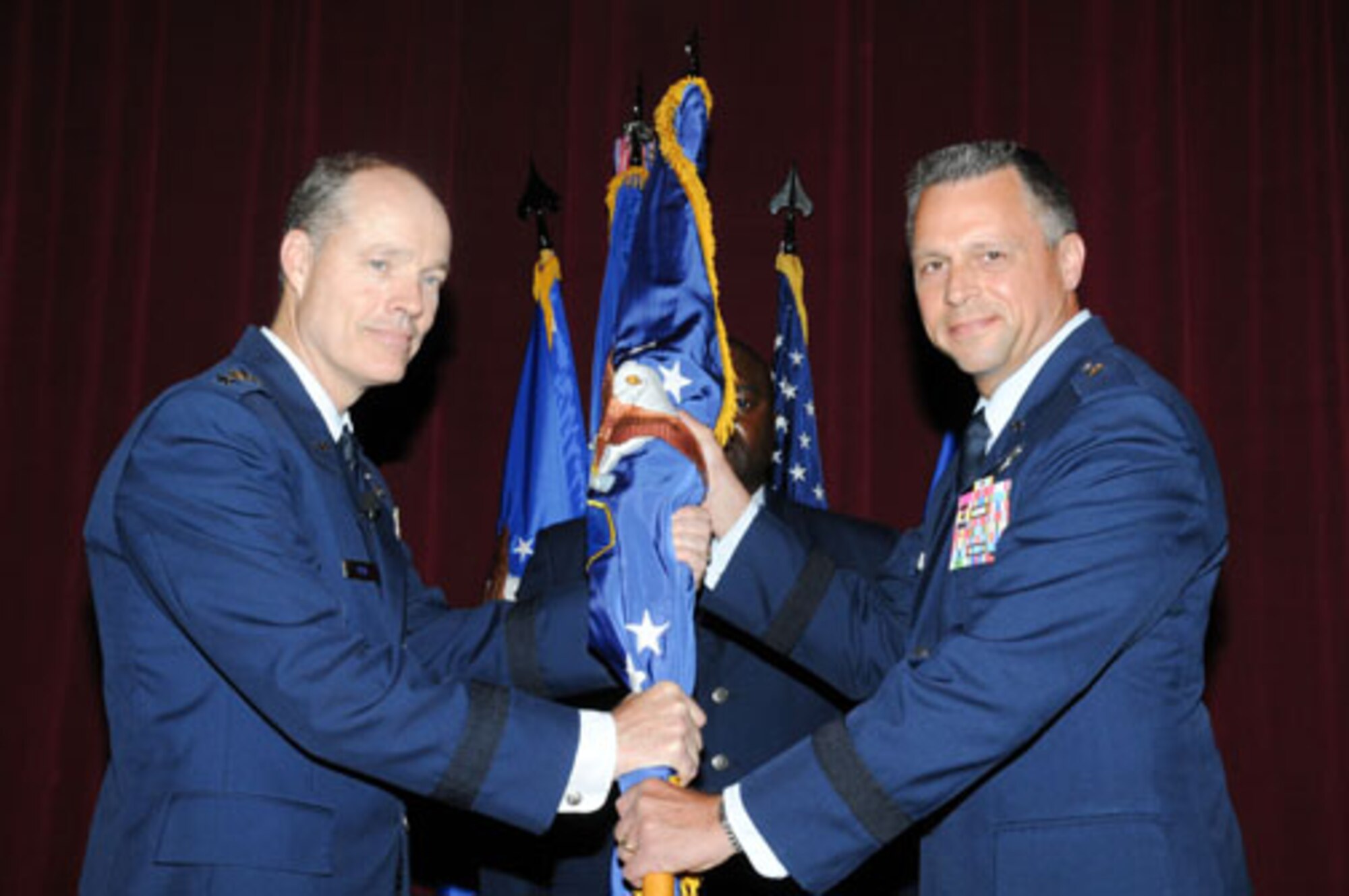Lt. Gen. Allen Peck, Air University commander, passes the guidon to Brig. Gen. Scott Hanson, new commander of the Carl A. Spaatz Center for Officer Education, at a ceremony May 27. (Air Force photo/Bud Hancock)