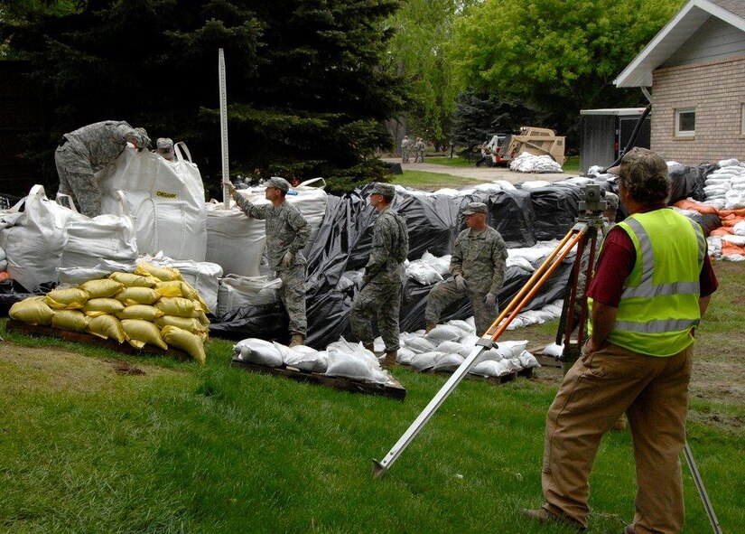 North Dakota National Guard members work with U.S. Army Engineer Corps and civil engineers from Morton County to ensure that levees are meeting the appropriate height and width to withstand anticipated flood waters in Mandan, N.D., June 2, 2011. (Photo by Sgt. Jesica Geffre, 116th Public Affairs Detachment)