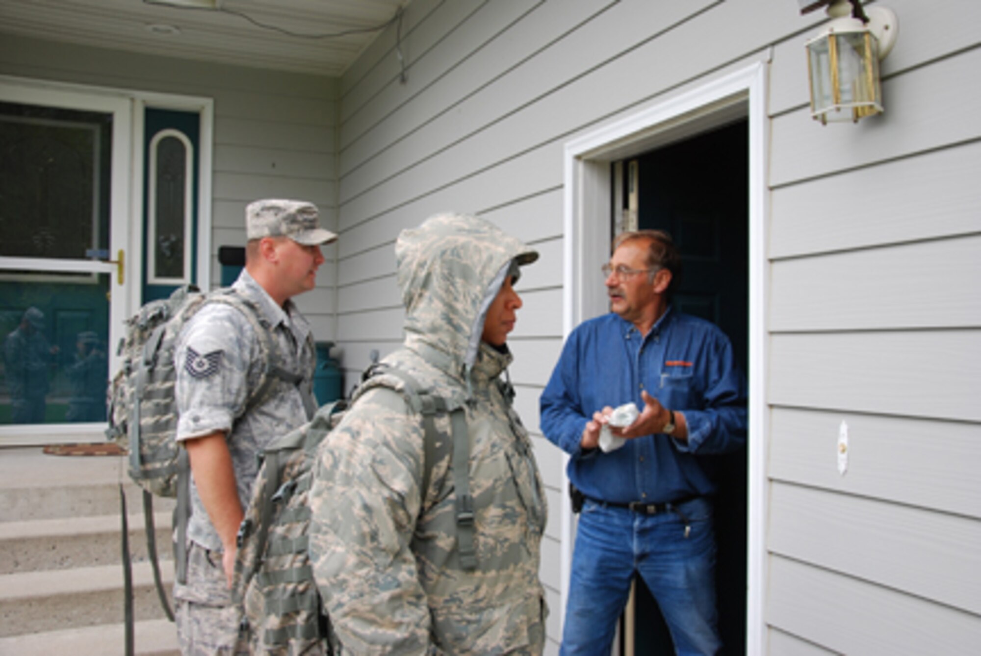 MINOT, N.D. -- Staff Sgt. Brandan Ressler and Staff Sgt. Briana Ford, of the North Dakota National Guard's 219th Security Forces Squadron, speak with Mike Neva, a homeowner in one of the evacuated areas, to ensure that he is aware of the evacuation. Ressler and Ford are two of about 50 Air Guard members doing presence patrols through the nine evacuated areas in Minot, N.D., June 2, 2011. The primary reason for the patrols is to provide a military presence in these areas to deter theft and vandalism, thereby protecting the homeowners that were required to leave. (Photo by Spc. Cassandra Simonton/116th Public Affairs Detachment)

 
