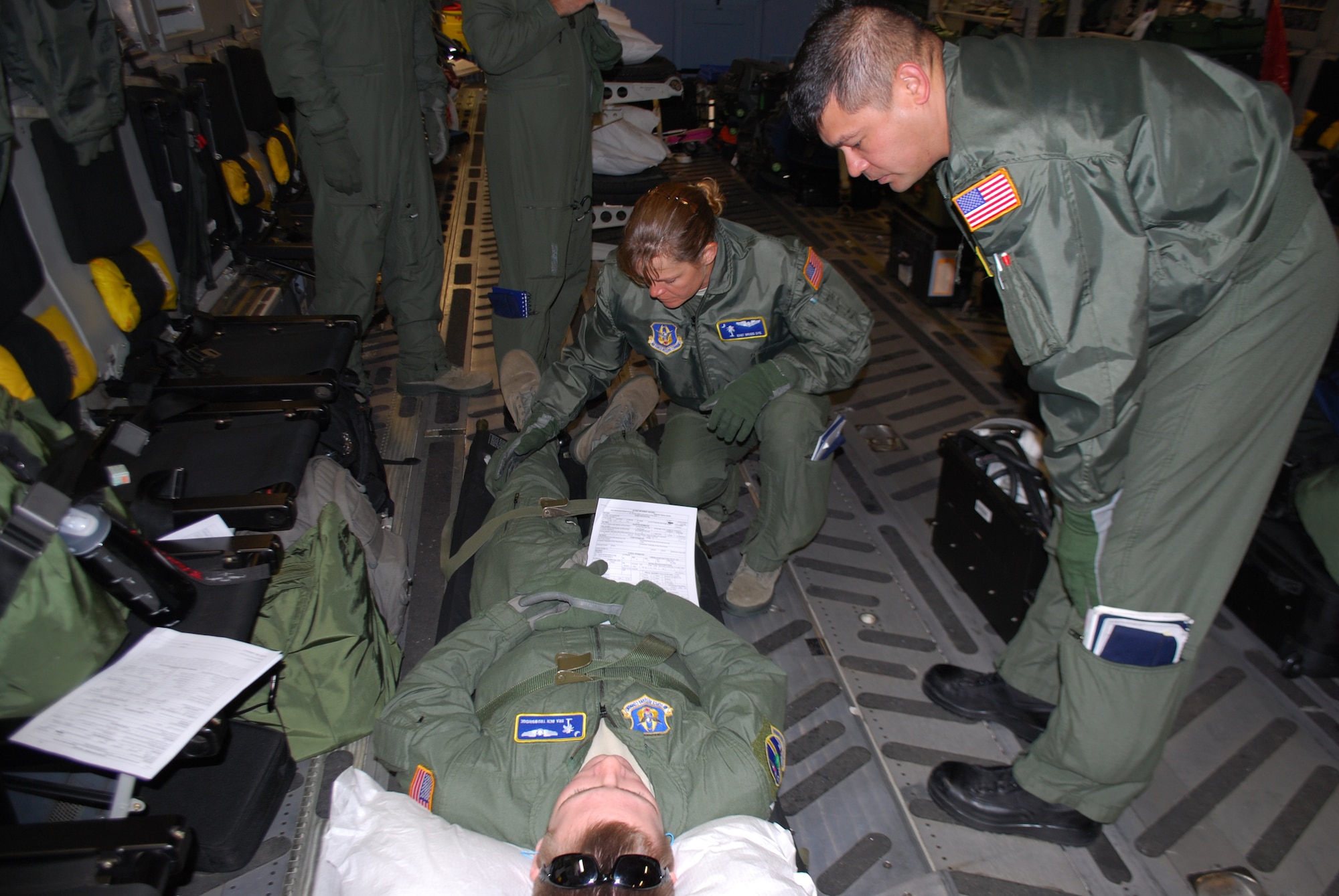Staff Sergeant Brigid Dye  (center), Technical Sergeant Deaun Davis (right), and Senior Airman Ben Trowbridge perform an aeromedical evacuation senario during aeromedical evacuation training on a C-17 Globemaster III.  Staff Sgt. Dye, Tech Sgt. Davis, and SrA Trowbridge are apart of the 315th Aeromedical Evacuation Squadron on Joint Base Charleston. (U.S. Air Force photo Lt. Col. Bill Walsh)