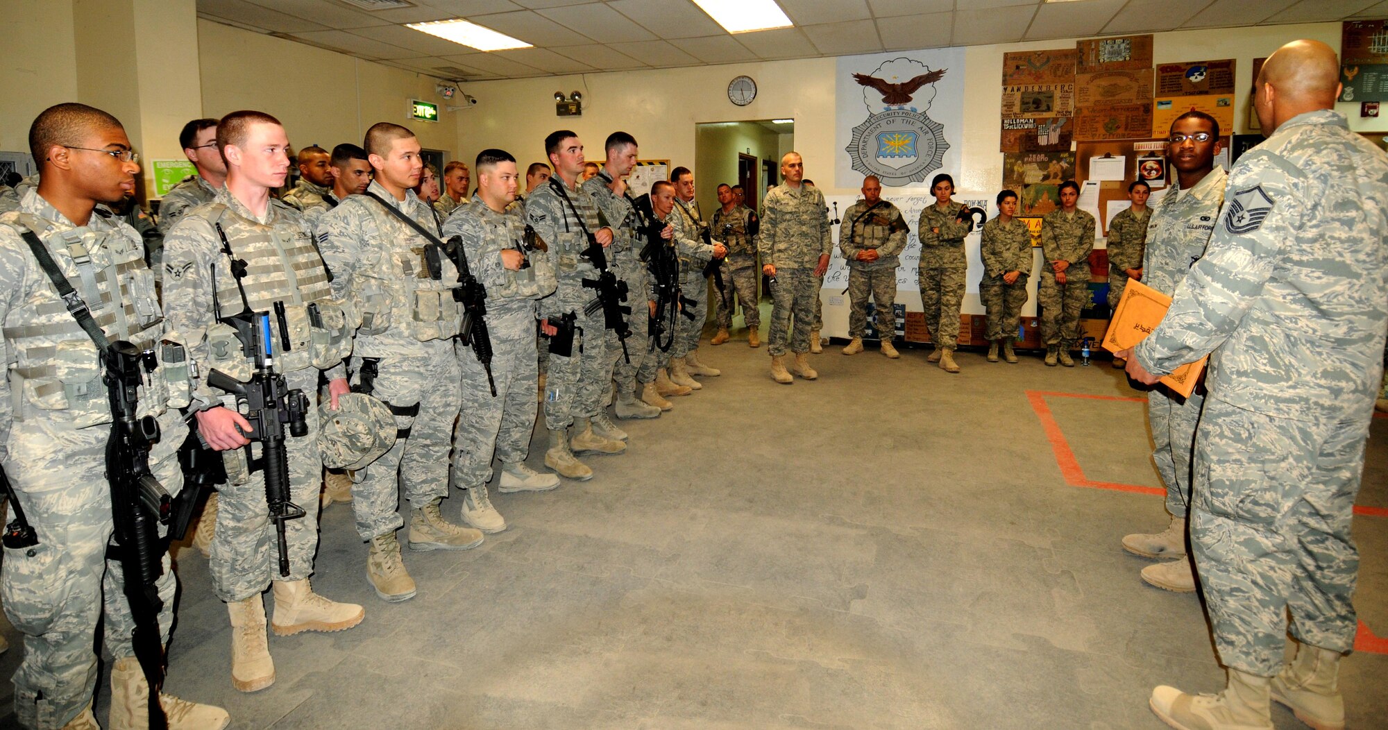 Members of the 386th Expeditionary Security Forces Squadron stand by as Staff Sgt. Gherjuan Robinson, a Defender with the 386th ESFS, is awarded the Top III Unsung Warrior award by Master Sgt. Marcus Jones. The award is given in two categories, Airman and NCO, to individuals who "genuinely inspire and contribute (often behind the scenes) to the improvement of customer service, quality of life and overall mission accomplishment at the 386th AEW." (U.S. Air Force photo by Staff Sgt. Patrice Clarke)