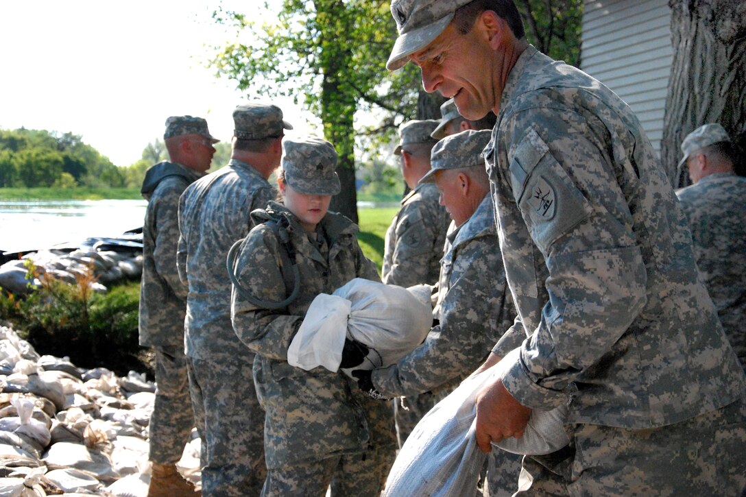 Nationals Guardsmen form a sandbagging line behind the Dakota Rose Bed and Breakfast in Minot, N.D., June 1, 2011. The soldiers are assigned to the 3662nd Maintenance Company, North Dakota National Guard. About 600 soldiers and airmen from the North Dakota National Guard have been activated to Minot to assist in flooding operations.