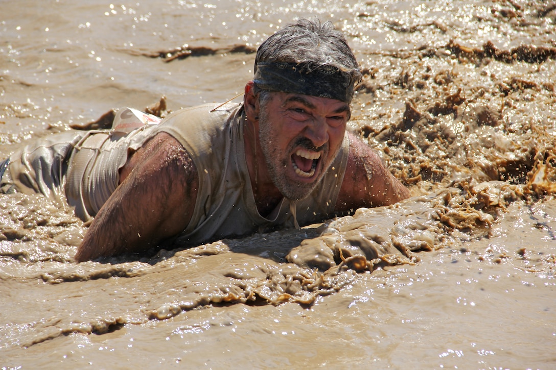 A participant of Marine Corps Community Service's "World Famous Mud Run," sponsored by U.S. Marine Corps Forces, Special Operations Command, crawls through a 30-foot mud pit toward the finish line June 4, 2011. The 10k race is part of MCCS's Hard Corps Race Series. (Official U.S. Marine Corps photo courtesy of Monroe photography/Released)