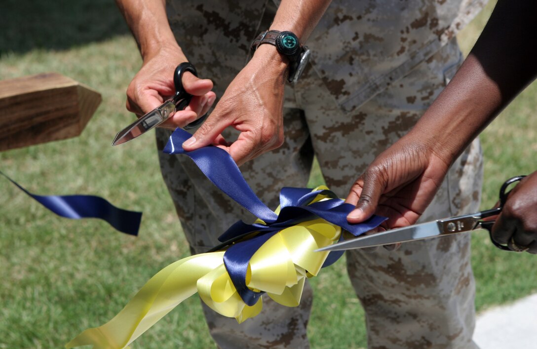 Navy Capt. Efren Saenz, the commanding officer for 2nd Medical Battalion, 2nd Marine Logistics Group, and Navy Lt. Jinaki Gourdine, the commanding officer for Preventive Medicine Unit, 2nd MLG, cut a ribbon during a ceremony in honor of their new facilities aboard Camp Lejeune, N.C., June 3, 2011. The facility will be used to conduct their daily duties such as water maintenance, and is a step up from their previous location, which has since been condemned. (U.S. Marine Corps photo by Pfc. Franklin E. Mercado)