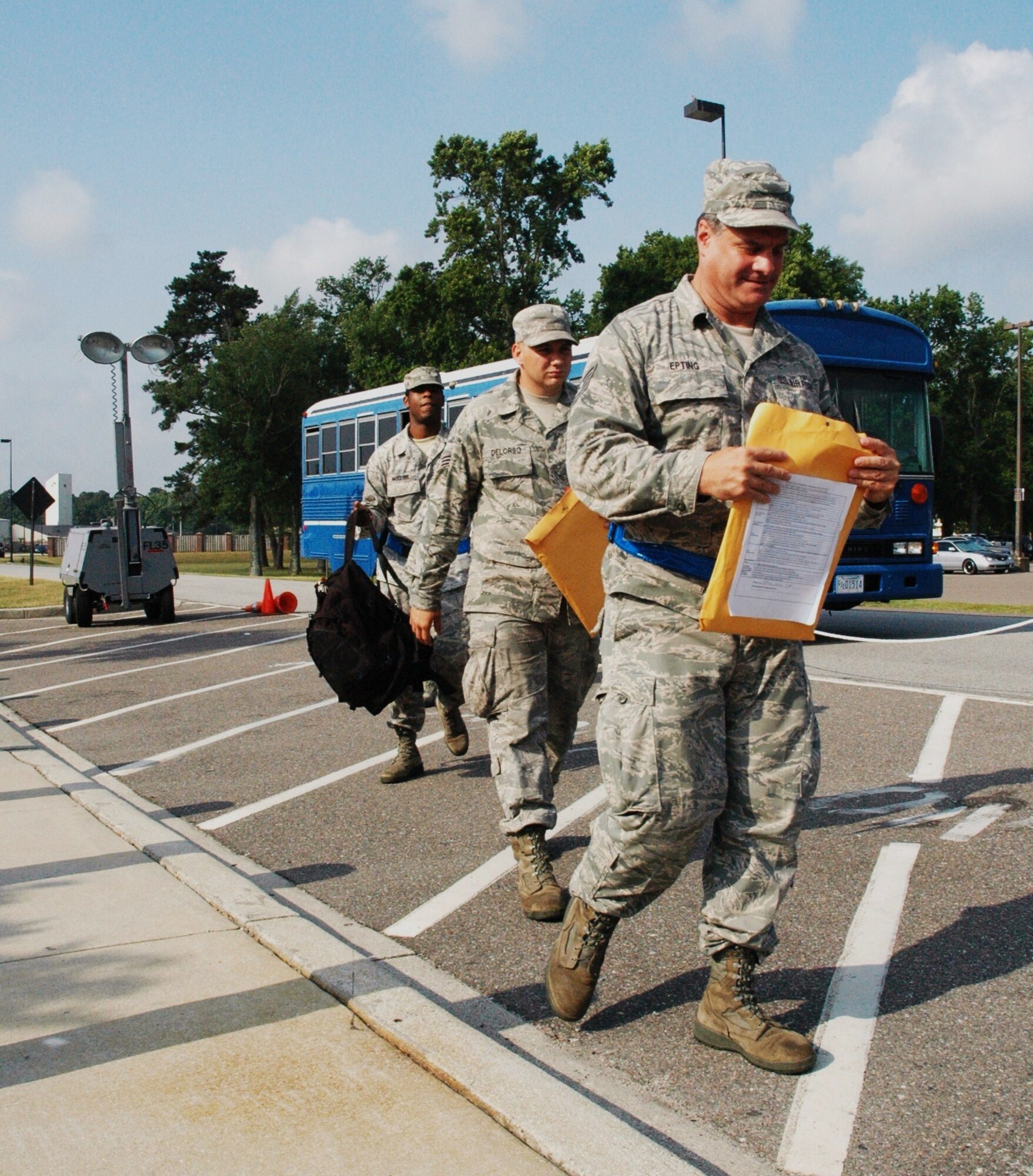 Three airmen of the 315th Airlift Wing at Joint Base Charleston, S.C. depart a bus at the passenger terminal as they continue processing for deployment during an operational readiness exercise at Joint Base Charleston, S.C. on June 4, 2011.