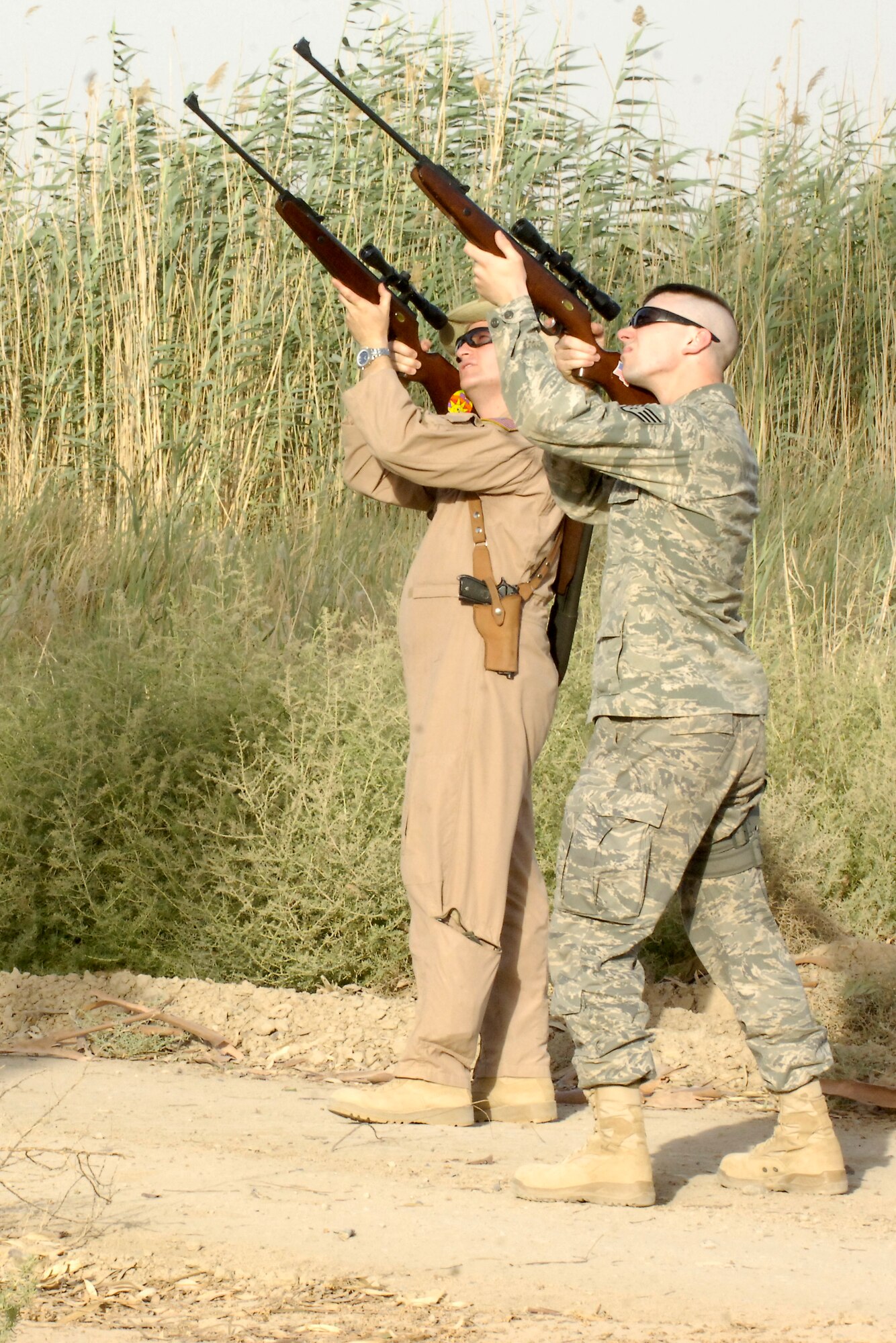 BAGHDAD INTERNATIONAL AIRPORT – Maj. David Aumack, 321st Air Expeditionary Wing Safety flight safety officer, and Staff Sgt. Levi Riendeau, 321st AEW photographer, take aim at a bird on the north end of the airport June 3 as part of the Bird/Wildlife Aircraft Strike Hazard program. Advisors from the Iraq Training and Advisory Mission – Air are planning to train the Iraqi air force on airfield management techniques, like the BASH program, in the coming months. (U.S. Air Force photo by Tech. Sgt. Randy Redman)