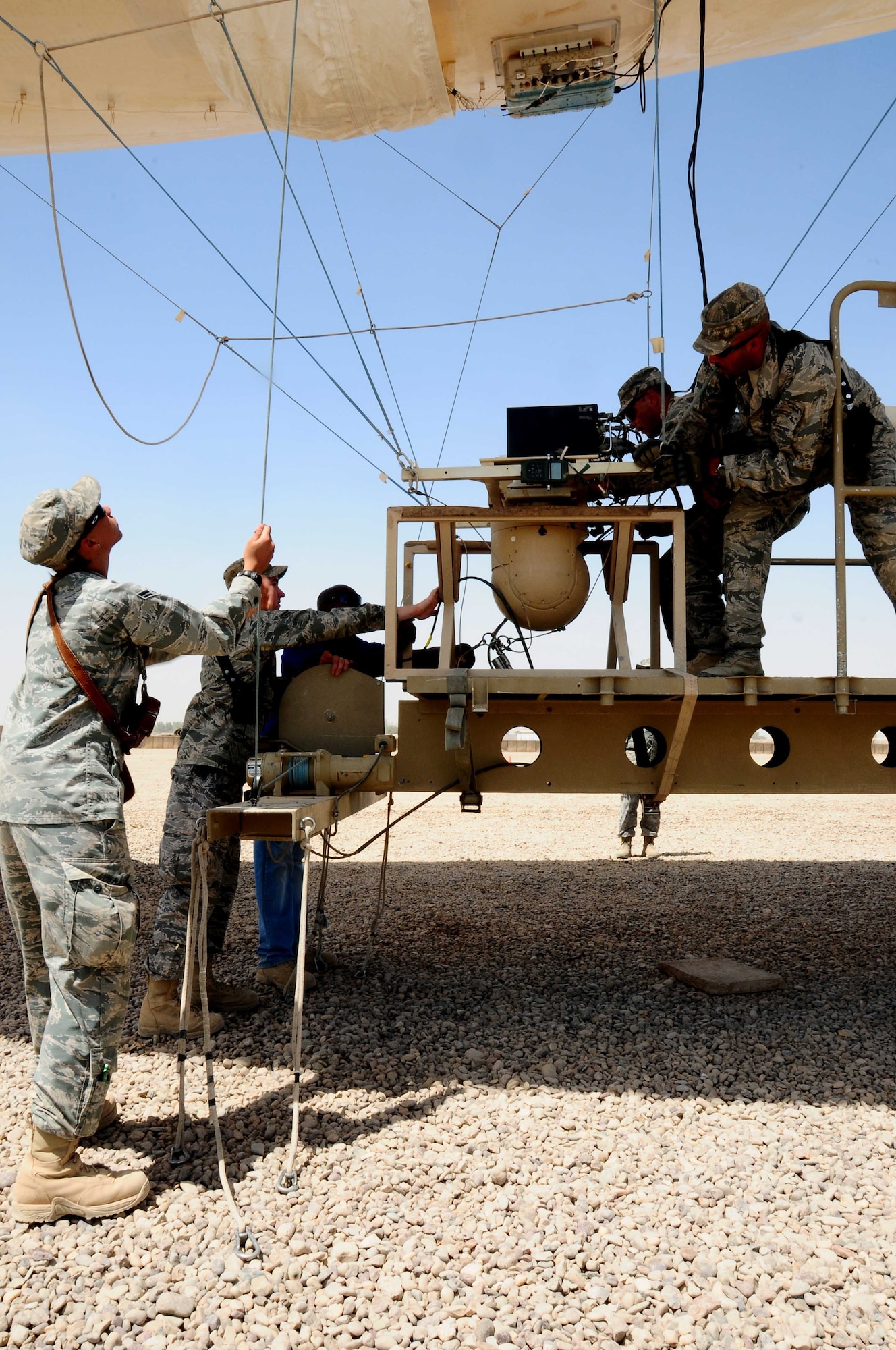 Airmen from the 332nd Expeditionary Security Forces Squadron perform an initial lauch and recovery of an aerostat June 3 at Joint Base Balad. The four airmen first class, who are all deployed from Beale Air Force Base, Calif., trained for three weeks to be the first Airmen to operate an aerostat. (U.S. Air Force photo by Airman 1st Class Jeffrey Schultze) 
