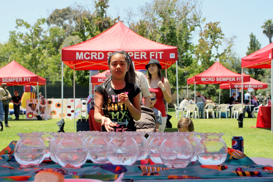 Chaelin, 8, throws a ping pong ball into fish tanks to win a gold fish at Summer Fest June 4 aboard Marine Corps Recruit Depot San Diego. Summer Fest provided carnival-style games and prizes to children for free.