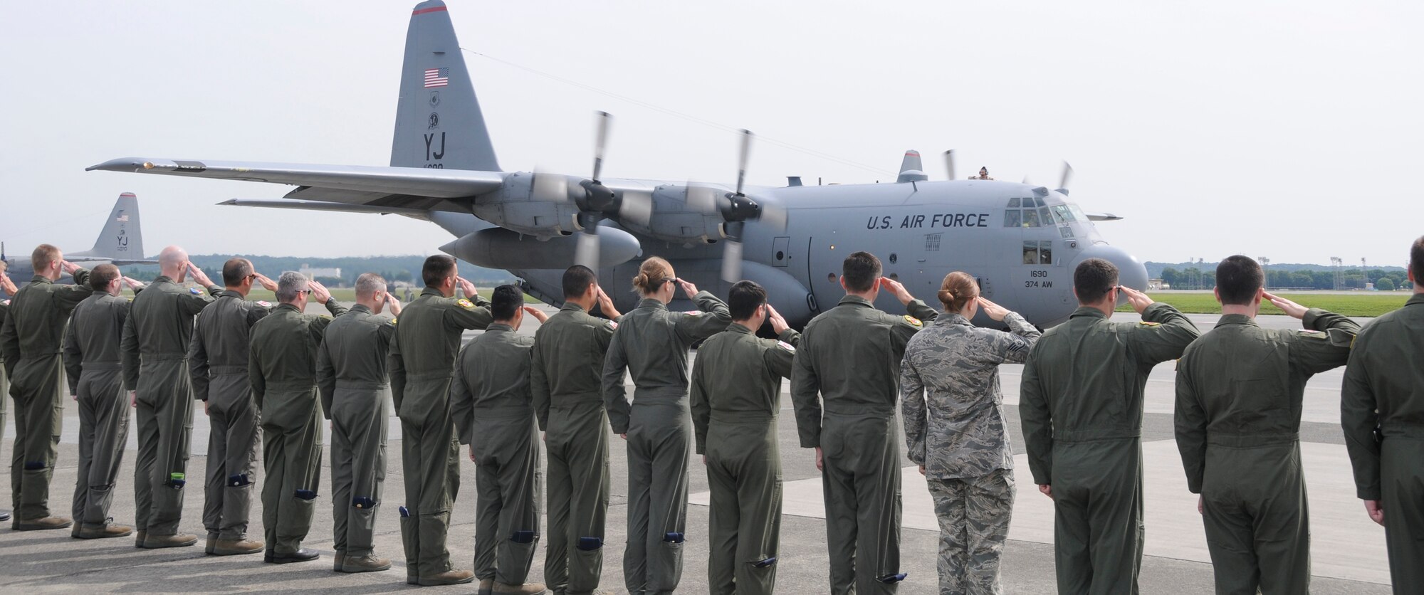 YOKOTA AIR BASE, Japan -- Members of the 36th Airlift Squadron salute as a C-130 Hercules departs, carrying fellow Airmen from the squadron at Yokota, June 3, 2011. Wing leadership, friends and family members came out to show support to the members as they depart on a deployment to Southwest Asia. (U.S. Air Force photo/Airman John D. Partlow)