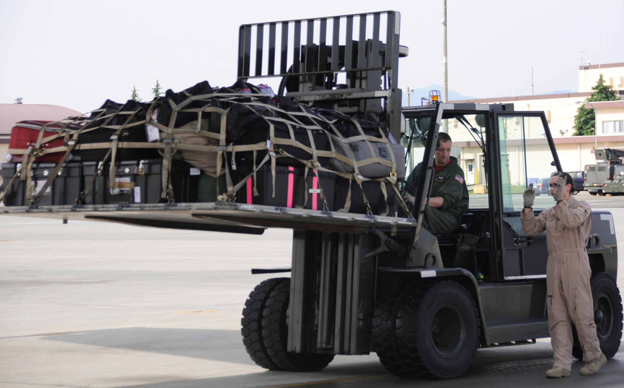 YOKOTA AIR BASE, Japan -- Staff Sgt. Charles Kirchen (left), and Senior Airman Jordanna Wilson, 36th Airlift Squadron loadmasters, load cargo on to a C-130 Hercules at Yokota, June 3, 2011. The cargo was for several members of the 36th AS who were deploying to Southwest Asia. (U.S. Air Force photo/Airman John D. Partlow)