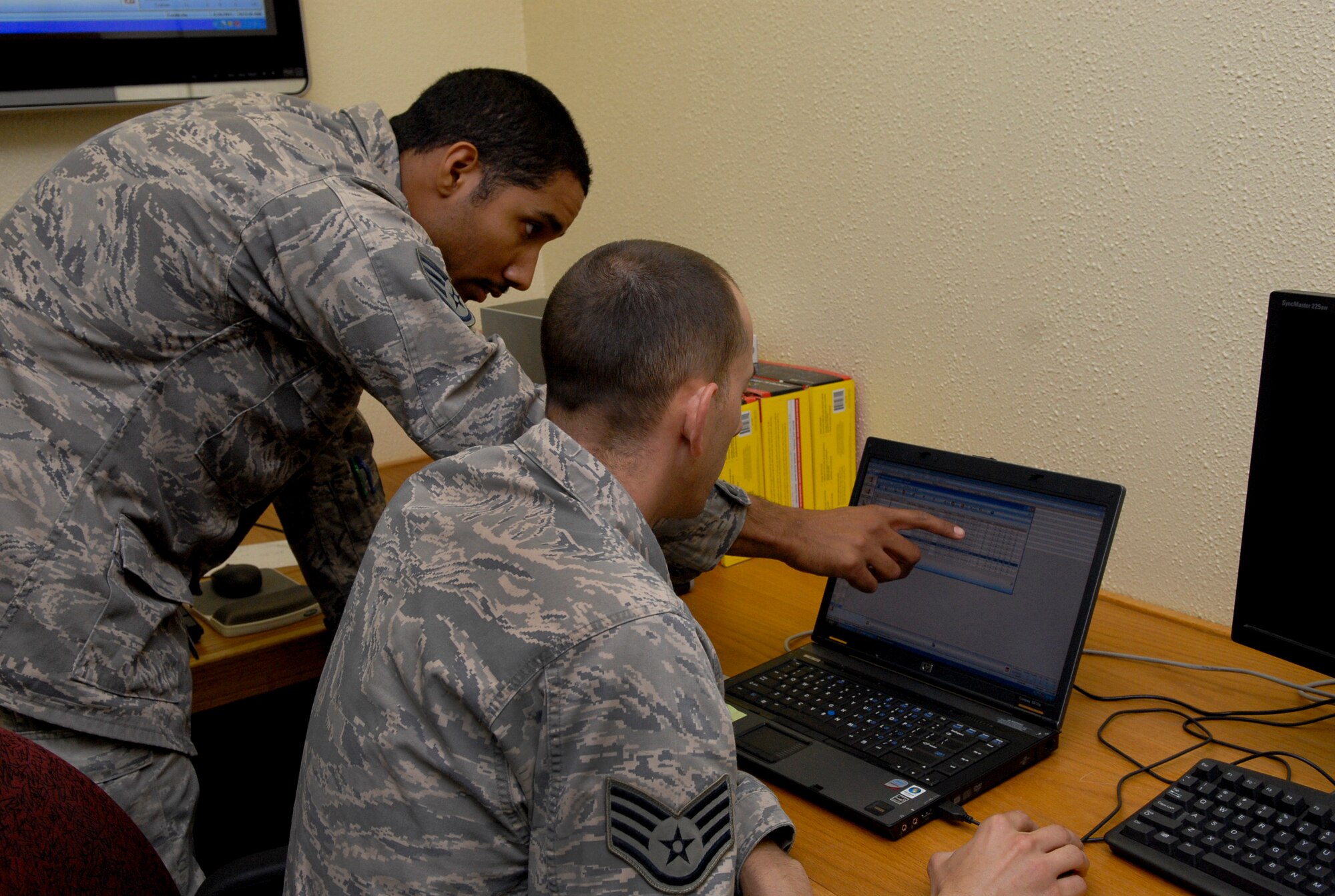 Staff Sgt. Timothy Allen and Staff Sgt. Warner Houston, 18th Civil Engineer Squadron control shop heating, ventilation, air conditioning and refrigeration craftsmen, review data collected by new electric meters installed on 150 buildings across Kadena recently. The meters are connected wirelessly to a control point where 18th CES can access and review transmitted data on energy use around the base. (U.S. Air Force photo/ Airman 1st Class Tara A. Williamson)