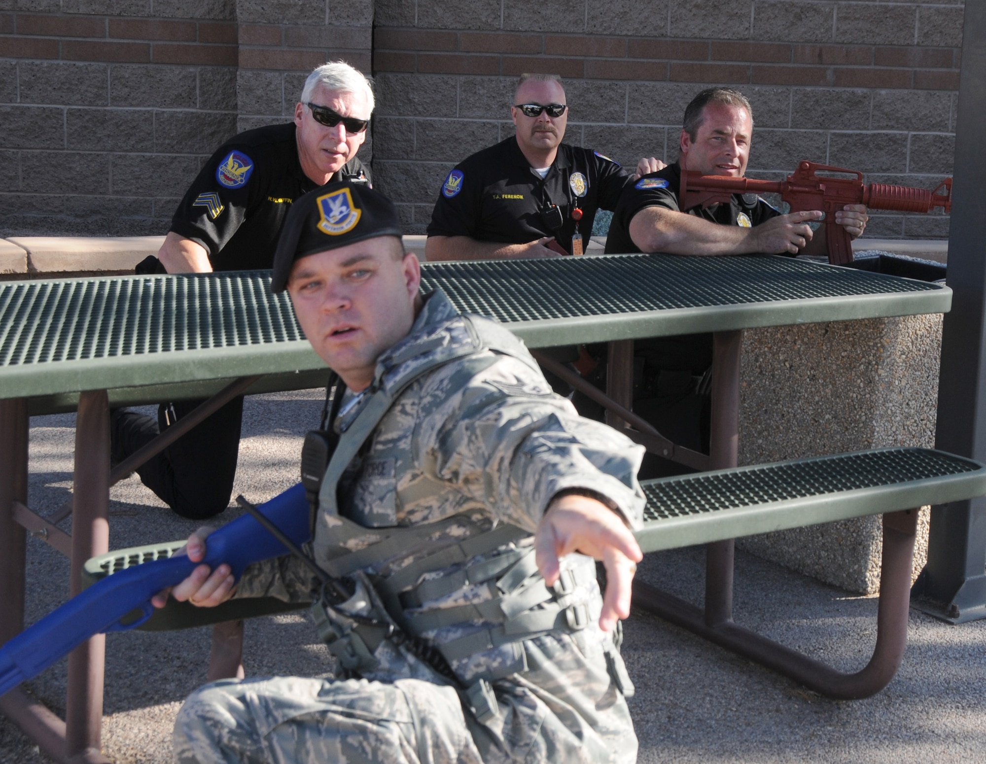 During an active shooter exercise, members of the Air National Guard, the Phoenix Police Department, the Federal Aviation Administration and the Transportation Security Agency work together to execute proper breaching and clearing techniques, at the 161st Air Refueling Guard base, Phoenix, June 4, 2011. This exercise helps to improve interagency communication and coordinate strategic planes. (U.S. Air Force photo by Staff Sgt. Courtney Enos/Released)
