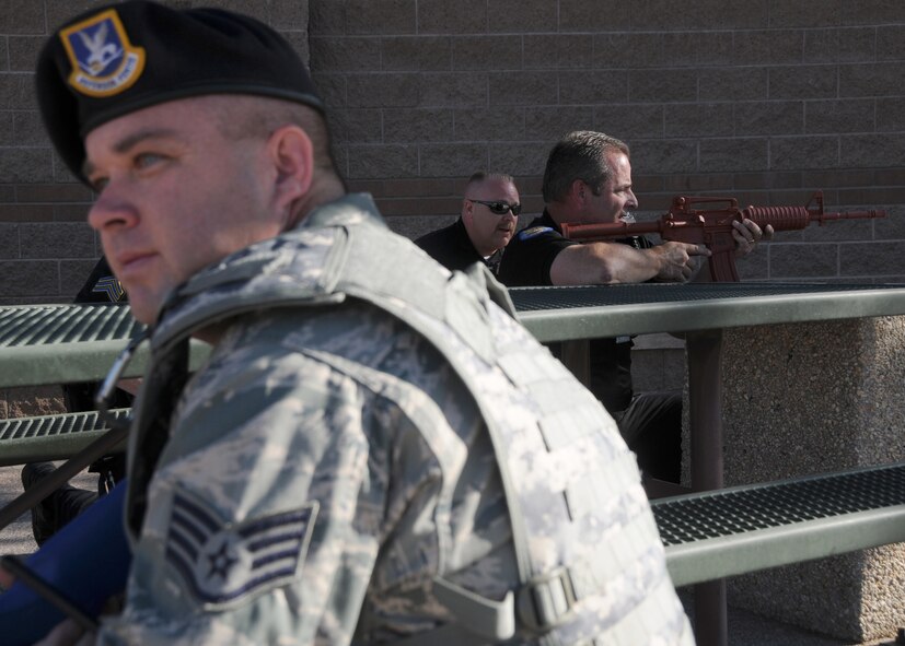 U.S. Air Force Staff Sgt. David Griffin, 161st Security Forces Squadron member, executes 360 degrees of surveillance as part of a simulated active shooter exercise at the 161st Air Refueling Guard base, Phoenix, June 4, 2011. This exercise brings together members of the Air National Guard, the Phoenix Police Department, the Federal Aviation Administration and the Transportation Security Agency in order to improve interagency communication. (U.S. Air Force photo by Staff Sgt. Courtney Enos/Released) 
