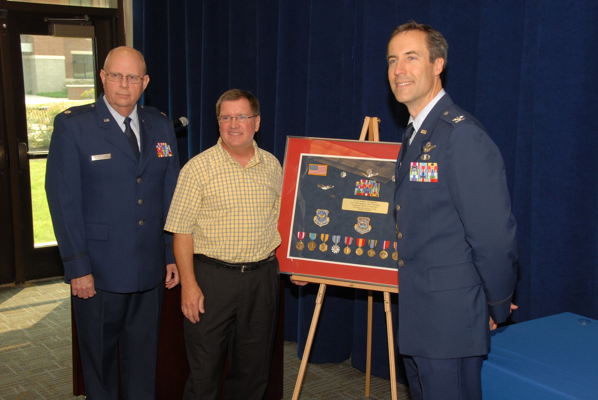 Mark E. Brown, retired Lieutenant Colonel, poses with, Lieutenant Colonel Olen L. Spencer, Executive Support Officer for the 164th Airlift Wing and Colonel Mark J. Devine, 164th Airlift Wing Vice Commander during the retirement ceremony held for Mr. Brown on the 4th of June, 2011.