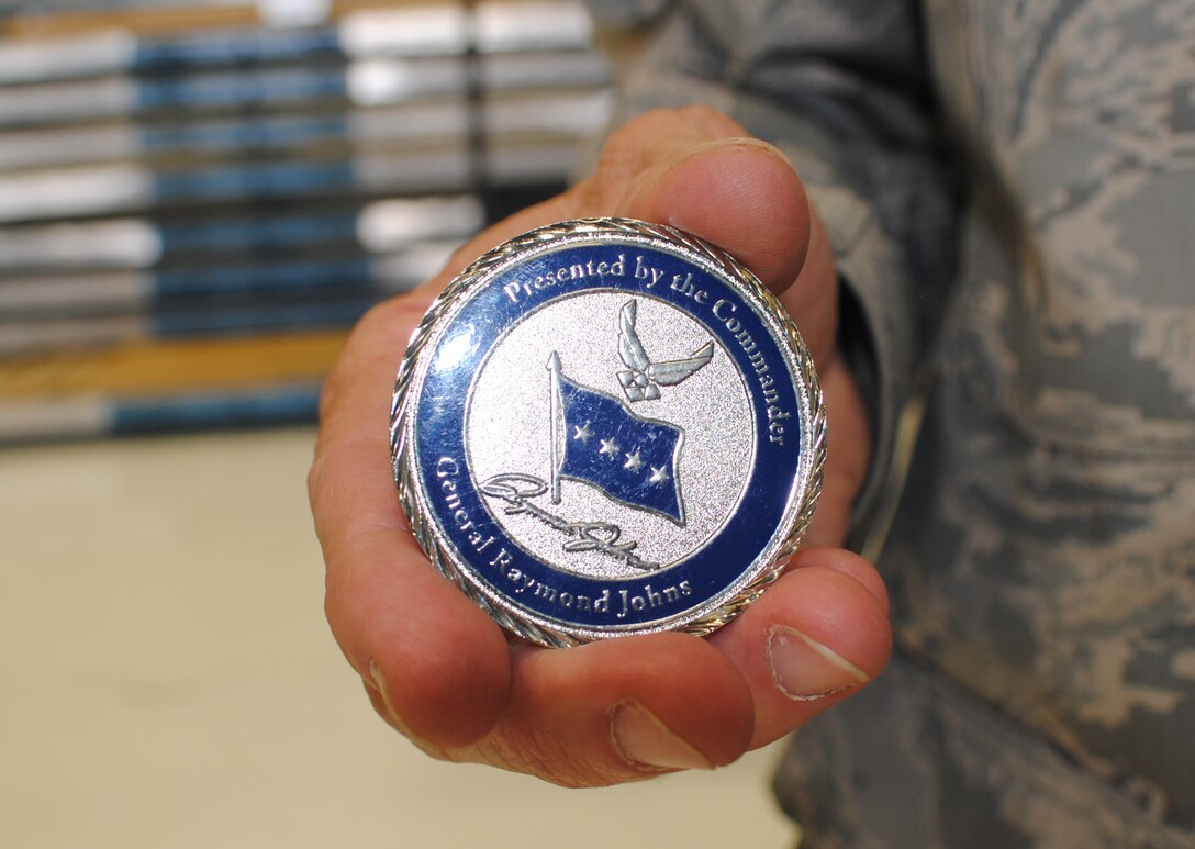 Technical Sgt. David Alsip, a sheet metal mechanic with the 433rd Aircraft Maintenance Squadron, proudly displays the coin given to him by Air Mobility Command commander, Gen. Raymond E. Johns Jr., May 9, 2011 at Lackland Air Force Base, Texas. The Alamo Wing NCO was one of at least eight Airmen coined during the four-star general’s visit. Sergeant Alsip received a coin for being the master-mind behind the wing's C-5 Galaxy aircraft panel creation system, which has helped save the wing save thousands of dollars. (U.S. Air Force photo/Senior Aiman Luis Loza Gutierrez)