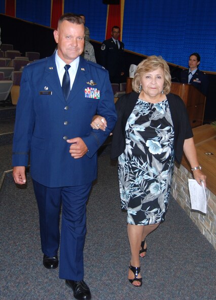 Members of the 433rd Airlift Wing gather to honor Nelda Perez, longtime civil servant, during her retirement ceremony. Here, Colonel William J. Rolocut, 433rd Operations Group commander, escorts Perez to the stage in the 68th Airlift Squadron's auditorium June 4, 2011 at Lackland Air Force Base, Texas. (U.S. Air Force photo/ Tech. Sgt. Carlos J. Trevino)