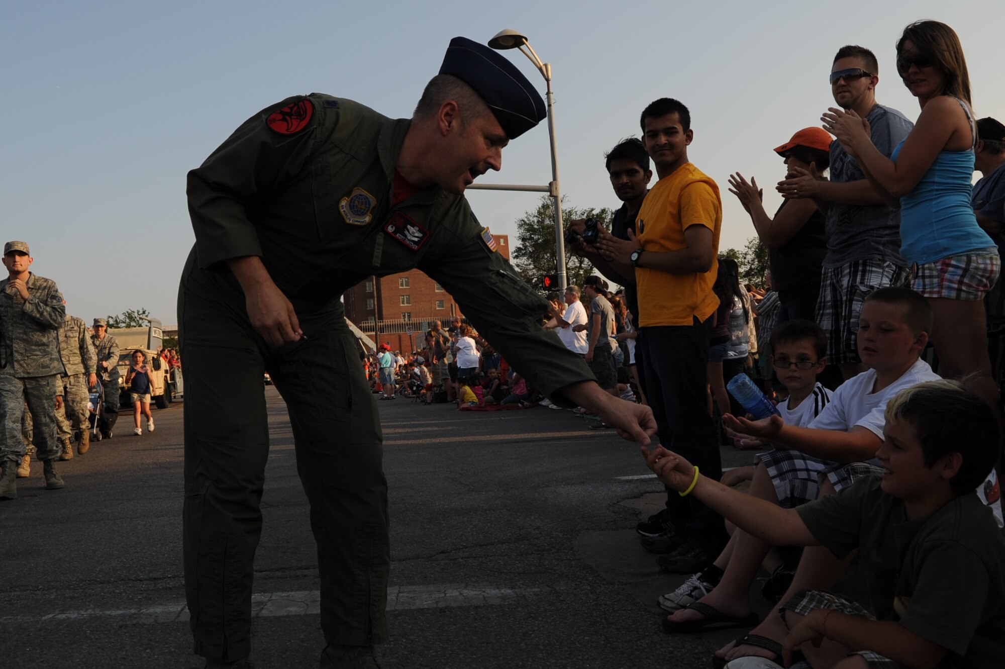 Lt. Col. Scott Thatcher, commander, 350th Air Refueling Squadron hands out coins to spectators watching the parade marking the opening of the annual Riverfest ceremonies in Wichita, June 3.  Airmen from McConnell Air Force Base, including the 931st Air Refueling Group and the 22nd Air Refueling Wing marched in the parade. (Air Force photo by Tech. Sgt. Brannen Parrish)