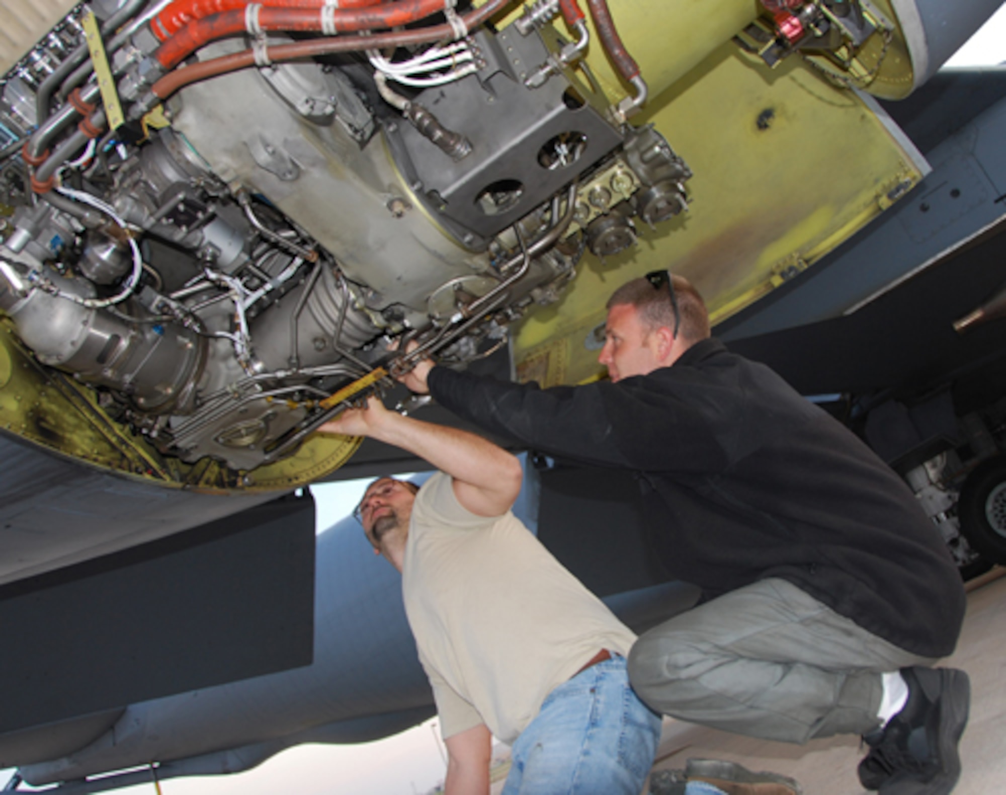 Tech. Sgt. Bryan Jones (right) shows Senior Airman John Brown different areas of Engine Three to be observed on the initial run. The maintainers liken the fan
blade calibration process (and importance) to balancing a tire on a car.