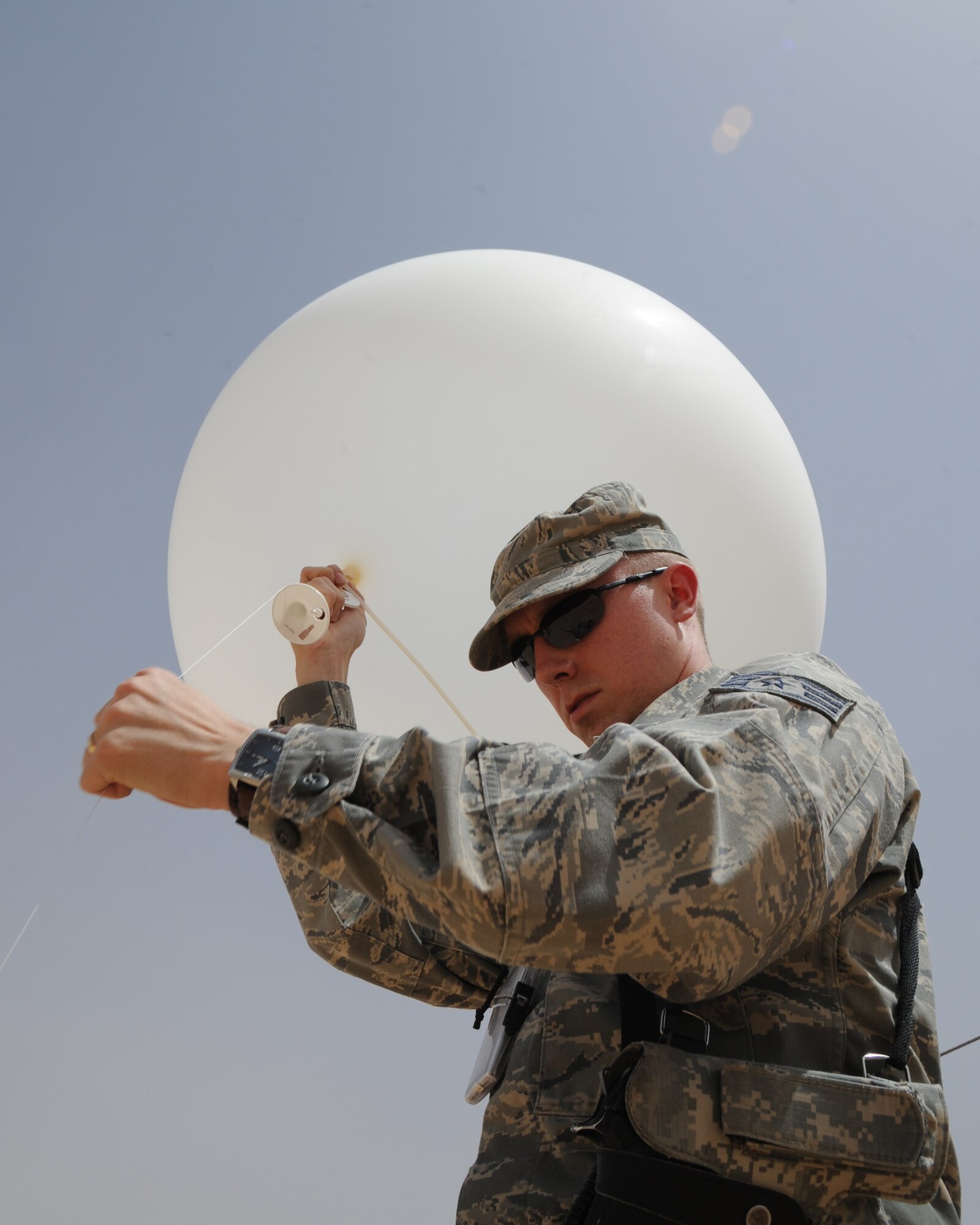 U.S. Air Force Staff Sgt. Casey Fletcher, 532nd Expeditionary Operations Support Squadron meteorologist prepares to launch a weather balloon into the air with a radiosonde attached to it by a string at Al Asad Air Base, Iraq, May 28, 2011. The radiosonde travels up with the weather balloon to transmit data back to a computer telling the wind speed, atmospheric pressure, temperature and humidity. (U.S. Air Force photo by Senior Airman Tristin English)