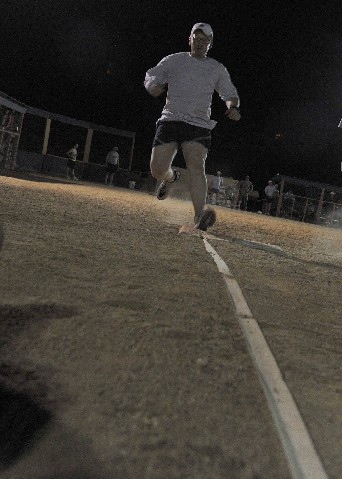 U.S. Air Force Airman 1st Class Joseph Dumdei, 532nd Expeditionary Operations Support Squadron, runs to first base during a softball game May 27, 2011, at Al Asad Air Base, Iraq. The ballpark started as a patch of uneven, unclaimed desert at the base in western Al Anbar Province. The Airmen, with the help of Soldiers, Sailors and civilian contractors, added lights, fences and dugouts. In the end, the finished product was a slice of Americana ready for the first game by opening day of the 2011 Major League Baseball season. (U.S. Air Force photo by Senior Airman Tristin English)