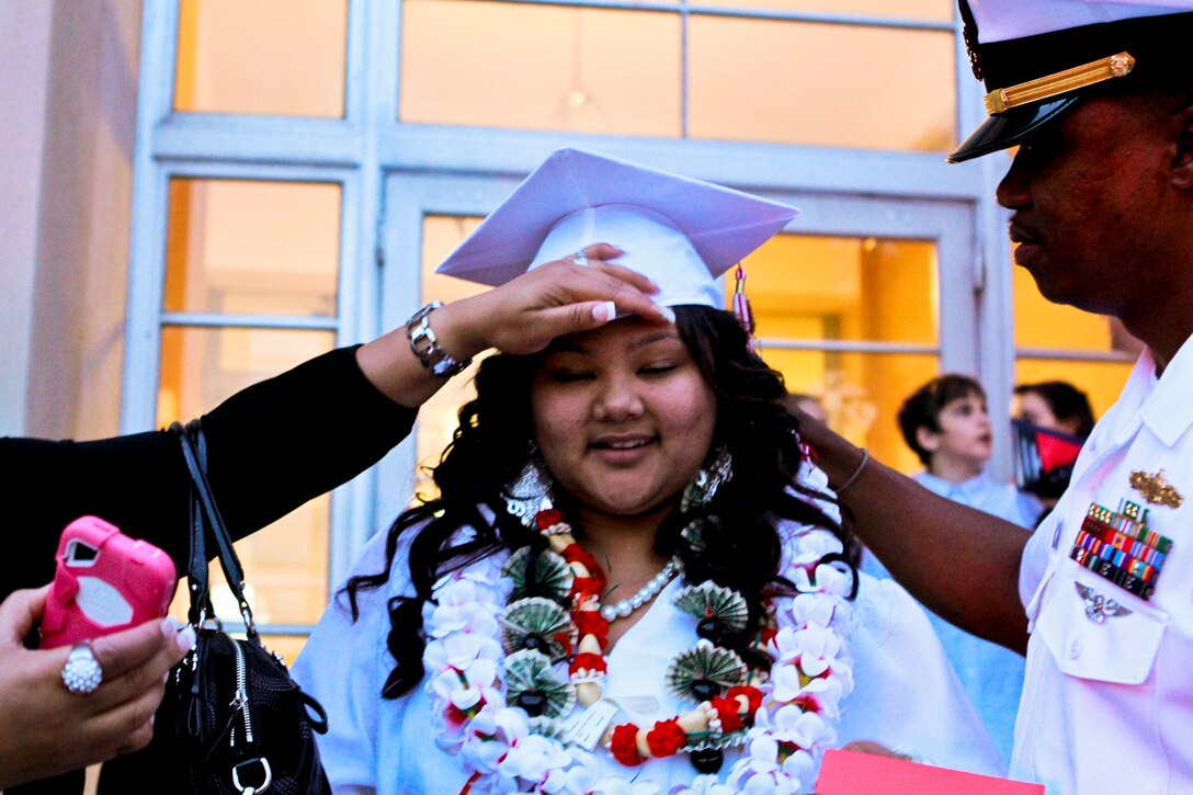 Naomi Chenelle Castro, a Quantico Middle/High School graduate who relocated from Japan after the earthquake earlier this year, gets help adjusting her cap from her father, U.S. Navy Ensign Irian Woodley outside the school on Marine Corps Base Quantico, Va., June 3, 2011.