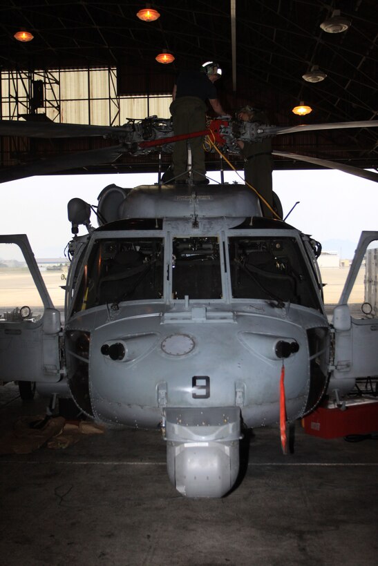 Two Helicopter Sea Combat Squadron 25 aviation electricians check the main rotor hub system of one of their MH-60S Knighthawk helicopters during a Phase D inspection at the HSC-25 hangar here June 6 .