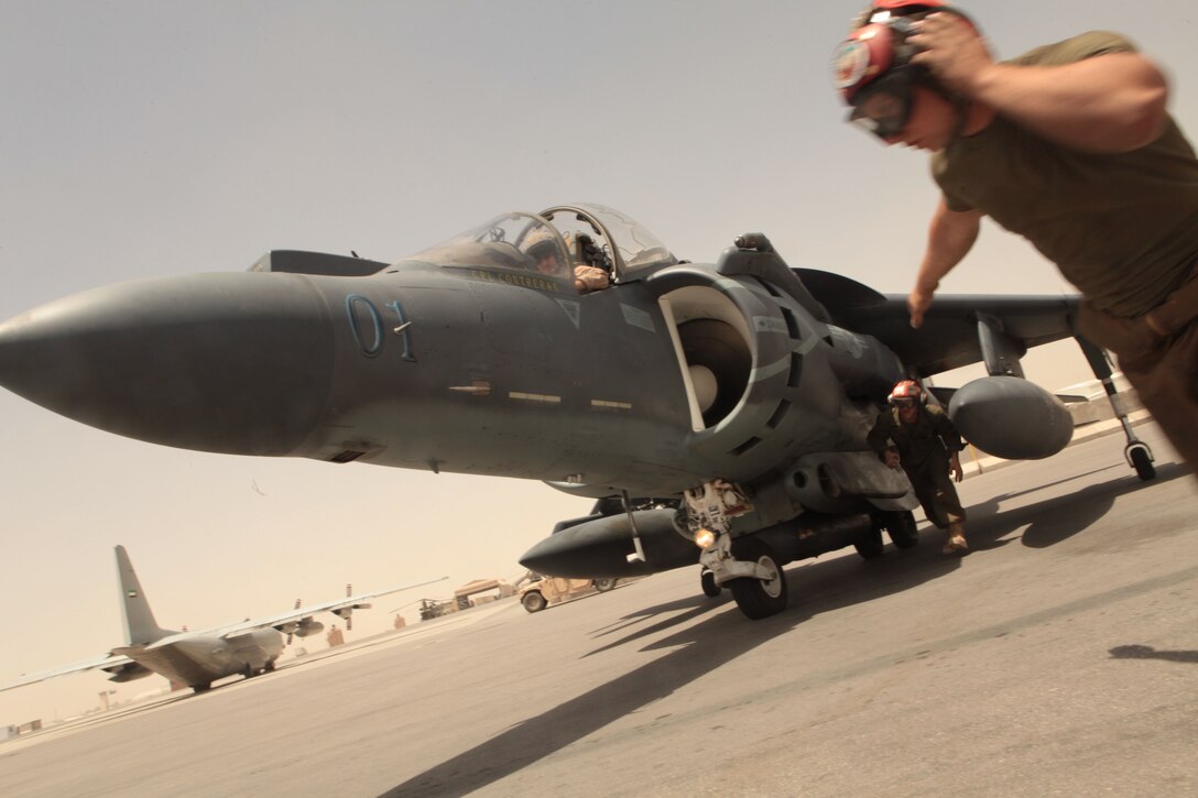 Lance Cpl. Kyle M. Rowe, a Marine Attack Squadron 513 ordnance technician and Troy, Ohio, native, signals to Lance Cpl. Peter E. Clary, also a VMA-513 ordnance technician and Moscow, Idaho, native, to disarm the other side of an AV-8B Harrier at Kandahar Airfield, Afghanistan, June 6.