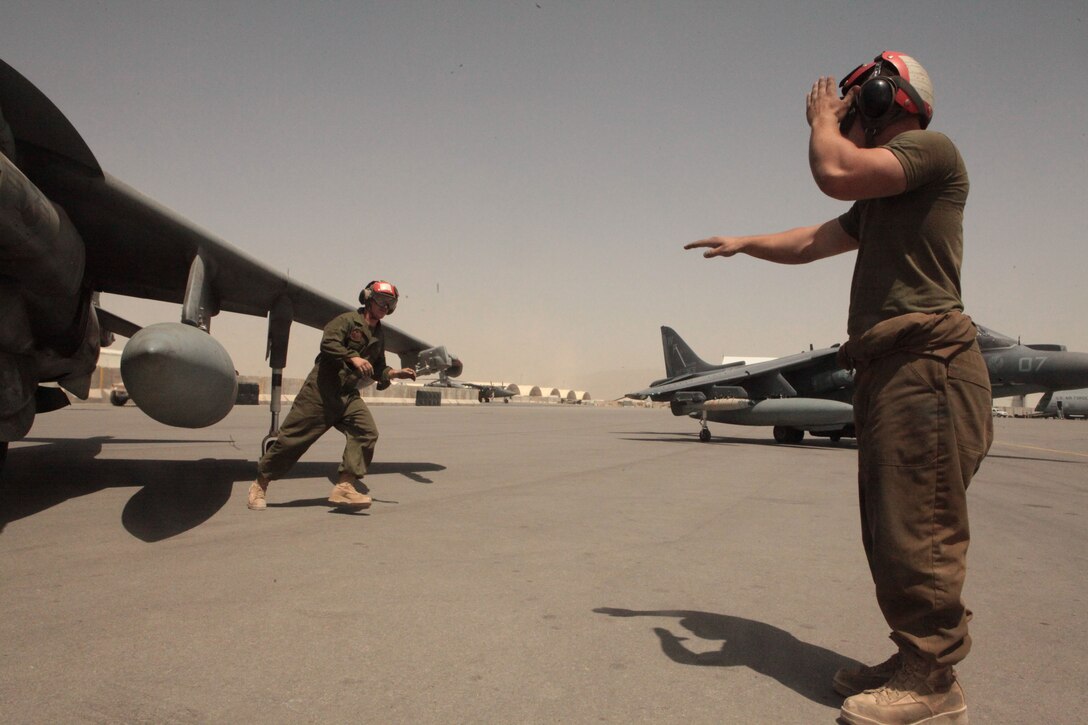 Lance Cpl. Peter E. Clary, left, a Moscow, Idaho, native, and Lance Cpl. Kyle M. Rowe, of Troy, Ohio, both Marine Attack Squadron 513 ordnance technicians, rush to arm two of the squadron’s AV-8B Harriers before they take off for a combat mission from Kandahar Airfield, June 6.