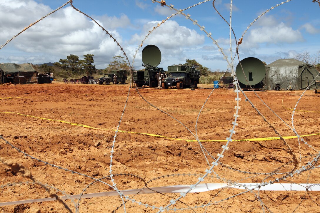 Marines with 7th Communication Battalion, III Marine Expeditionary Force Headquarters Group, III MEF, set up equipment at Landing Zone Dodo, Central Training Area, Okinawa, June 6. More than 230 Marines traveled to LZ Dodo for a field training exercise.