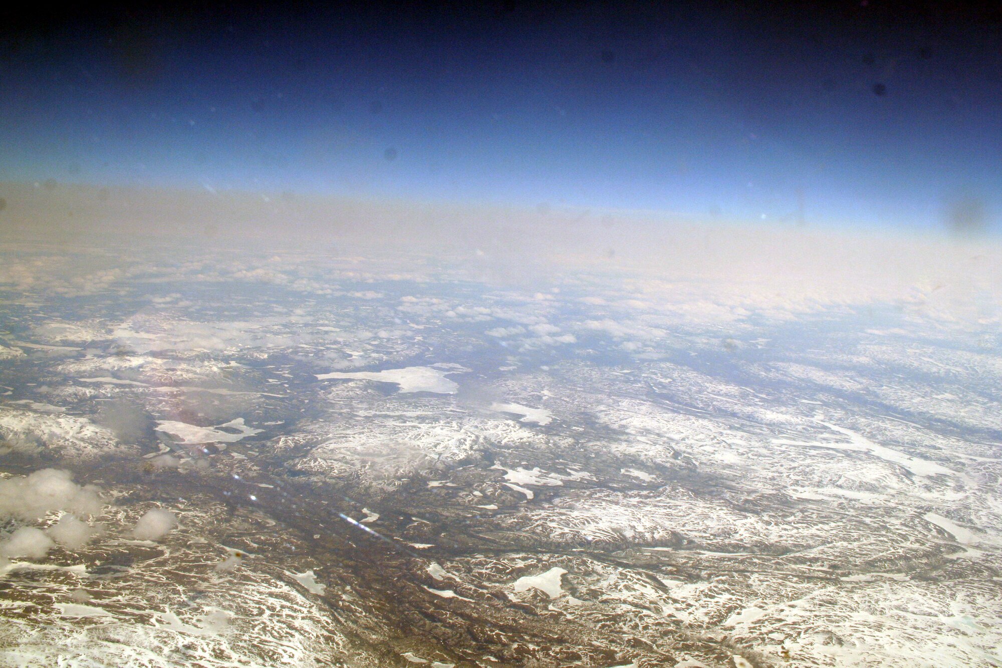 Ice-covered areas are seen from above the Arctic Circle from the window of a C-5M Super Galaxy on a  mission from Dover Air Force Base, Del., on June 5, 2011. The C-5M's mission was to complete the first Arctic overflight from Dover AFB to Bagram Airfield, Afghanistan. The plane successfully landed at Bagram just over 15 hours later on June 6, 2011. (U.S. Air Force Photo/Master Sgt. Scott T. Sturkol)