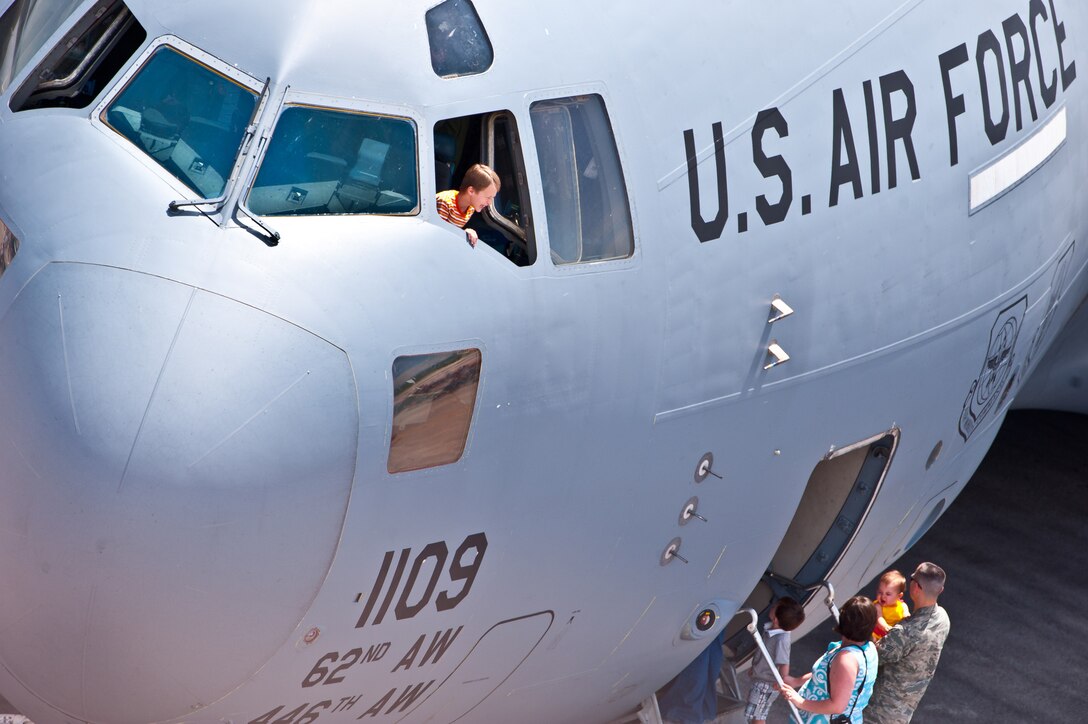 A boy smiles down at his parents from the cockpit of a C-17 Globemaster III static display during the 2011 Dakota Thunder airshow at Ellsworth Air Force Base, S.D., June 4, 2011. Nearly 40,000 people of all ages and walks of life converged here to watch the vast array of aerial demonstrations and view numerous static aircraft. (U.S. Air Force photo/Tech. Sgt. Nathan Gallahan)