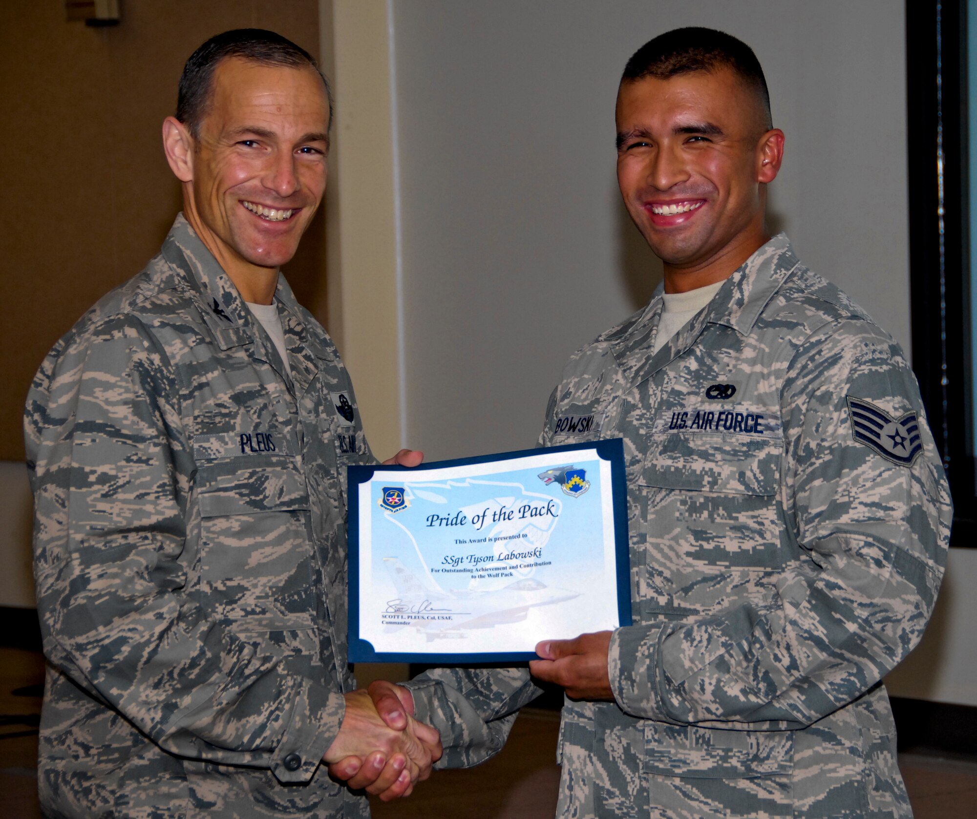 KUNSAN AIR BASE, Republic of Korea -- Col. Scott Pleus, 8th Fighter Wing commander, presents Tech. Sgt. Tyson T. Labowski, 8th Maintenance Squadron electrical and environmental systems journeyman, with a Pride of the Pack award here June 2. (U.S. Air Force photo/Capt. Sheryll Klinkel)