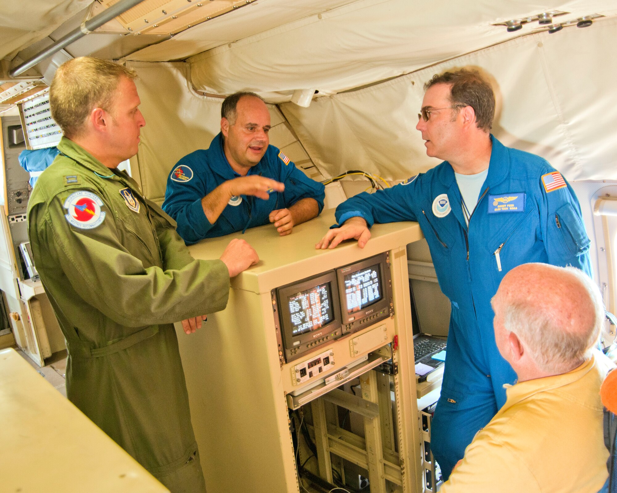 Two National Oceanic Atmospheric Administration electronics technicians, Mike Mascaro and Bobby Peek, discuss with Capt. Kyle Larson, 53rd Weather Reconnaissance Squadron weather officer, and Joseph McCormick, 336th Training Squadron, the similaries and differences of the WC-130J and WP-3 Orion. Since 2006 members of the 53rd WRS and National Oceanic Atmospheric Administration crewmembers have gathered each year to talk over procedures, data systems and storm coordination. This year the meeting was held here at Keesler Air Force Base. (U.S. Air Force photo by Maj. Heather Newcomb)