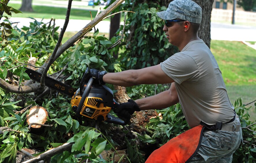 Staff Sgt. Reuben Dominguez, 2nd Civil Engineer Squadron, prepares to cut a tree branch on Barksdale Air Force Base, La. June 6. Airmen from the 2 CES were called to remove a fallen tree branch from a fence due to a storm the previous day. (U.S. Air Force photo/ Airman 1st Class Micaiah Anthony)(RELEASED)