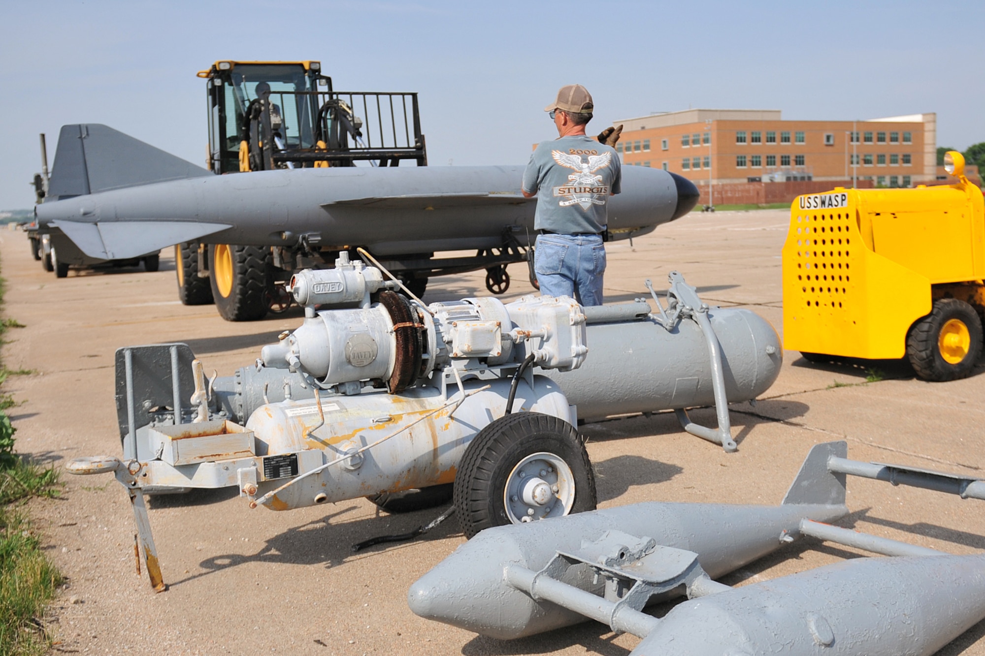 OFFUTT AIR FORCE BASE, Neb. -- Heavy equipment operators Gene Engram and Dale Harris, 55th Logistics Readiness Squadron, unload unload an old bomb casing that was moved to base from Freedom Park due to the rising water of the Missouri River. Freedom Park is an outdoor museum that features numerous military exhibits and has been overcome by rising waters of the Missouri River. Four members of the 55th LRS joined with other members of Team Offutt to move museum artifacts to higher ground until the flood waters recede. (U.S. Air Force photo by Jeff Gates)