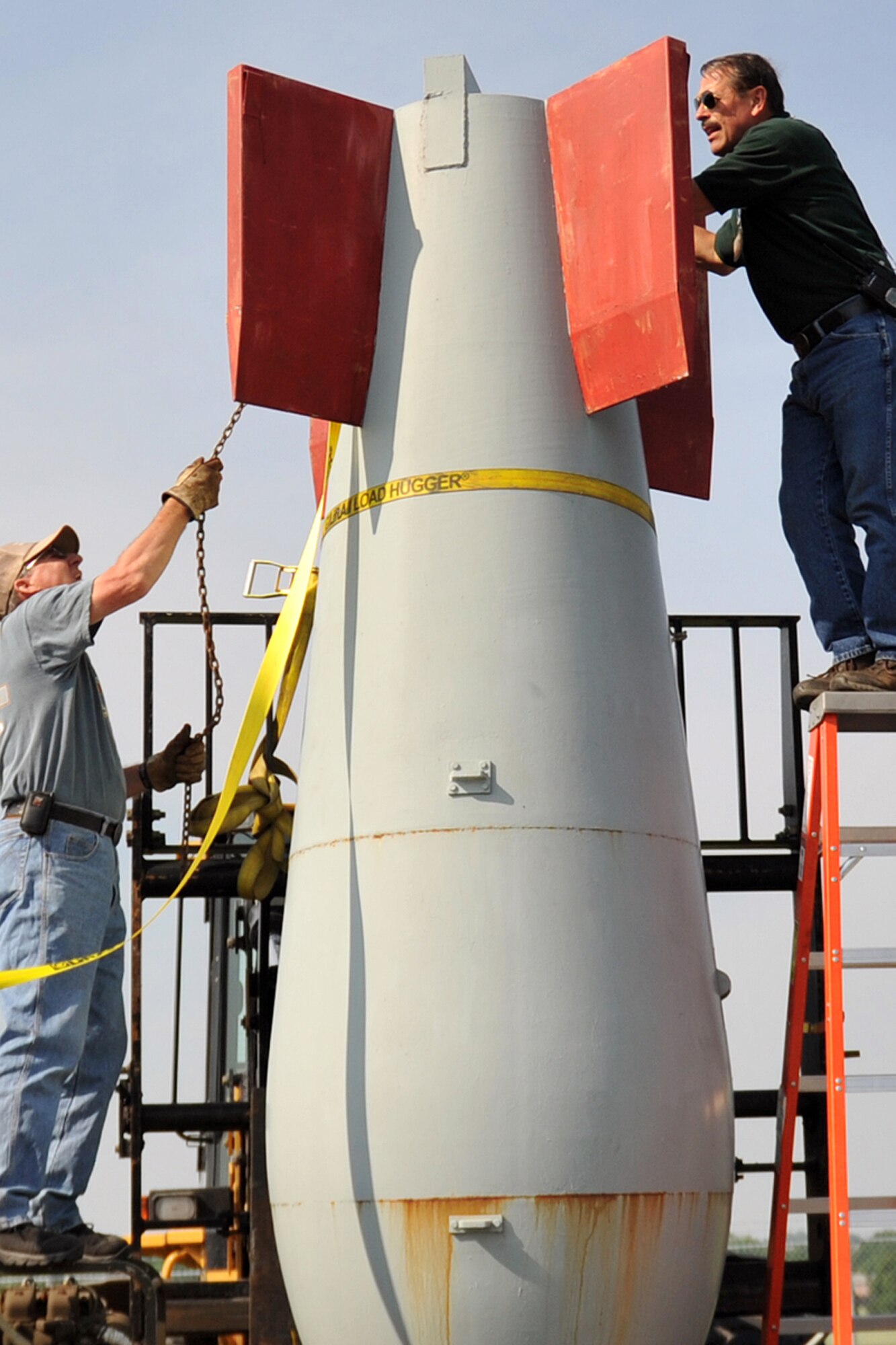 OFFUTT AIR FORCE BASE, Neb. -- Dale Harris, left, and Michael Wangberg, heavy equipment operators with the 55th Logistics Readiness Squadron, unload an old bomb casing that was moved to base from Freedom Park due to the rising water of the Missouri River. Freedom Park is an outdoor museum that features numerous military exhibits and has been overcome by rising waters of the Missouri River. Four members of the 55th LRS joined with other members of Team Offutt to move museum artifacts to higher ground until the flood waters recede. (U.S. Air Force photo by Jeff Gates)