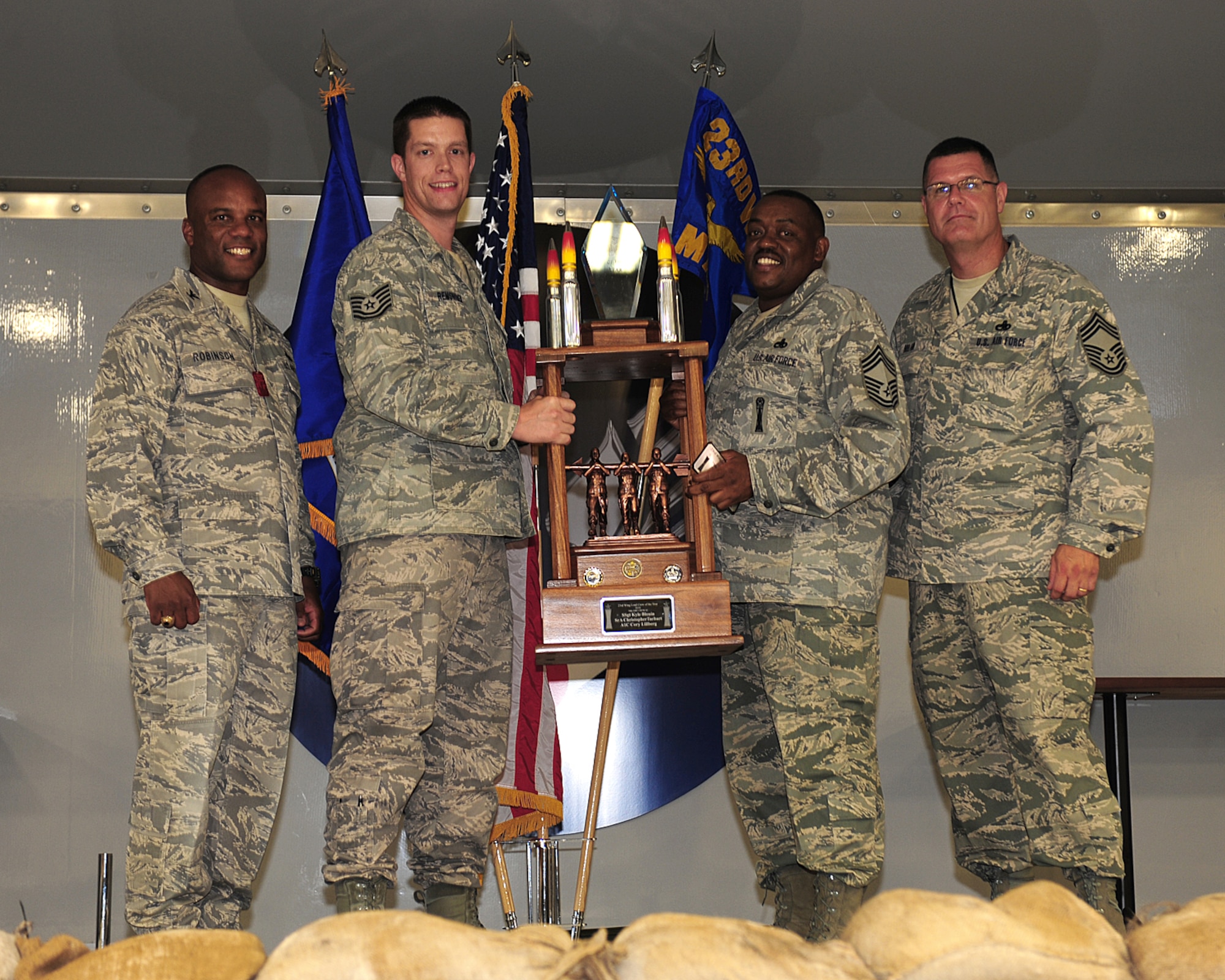 Chief Master Sgt. Kenneth Lilly, 23rd Maintenance Group, and Tech Sgt. Joel Remsnyder, 23rd Aircraft Maintenance Squadron  accepts  the Weapons Load Team of the Year award on behalf of Staff Sgt. Kyle Blouin, Senior Airman Christopher Tarbart and Airman 1st Class Corey Lillberg, 74th Aircraft Maintenance Unit, at Moody Air Force Base, Ga.,  June 2. This award is given each year to the best load team, which is determined by competitions held throughout the year. (U.S. Air Force photo/Senior Airman Stephanie Mancha)(RELEASED)