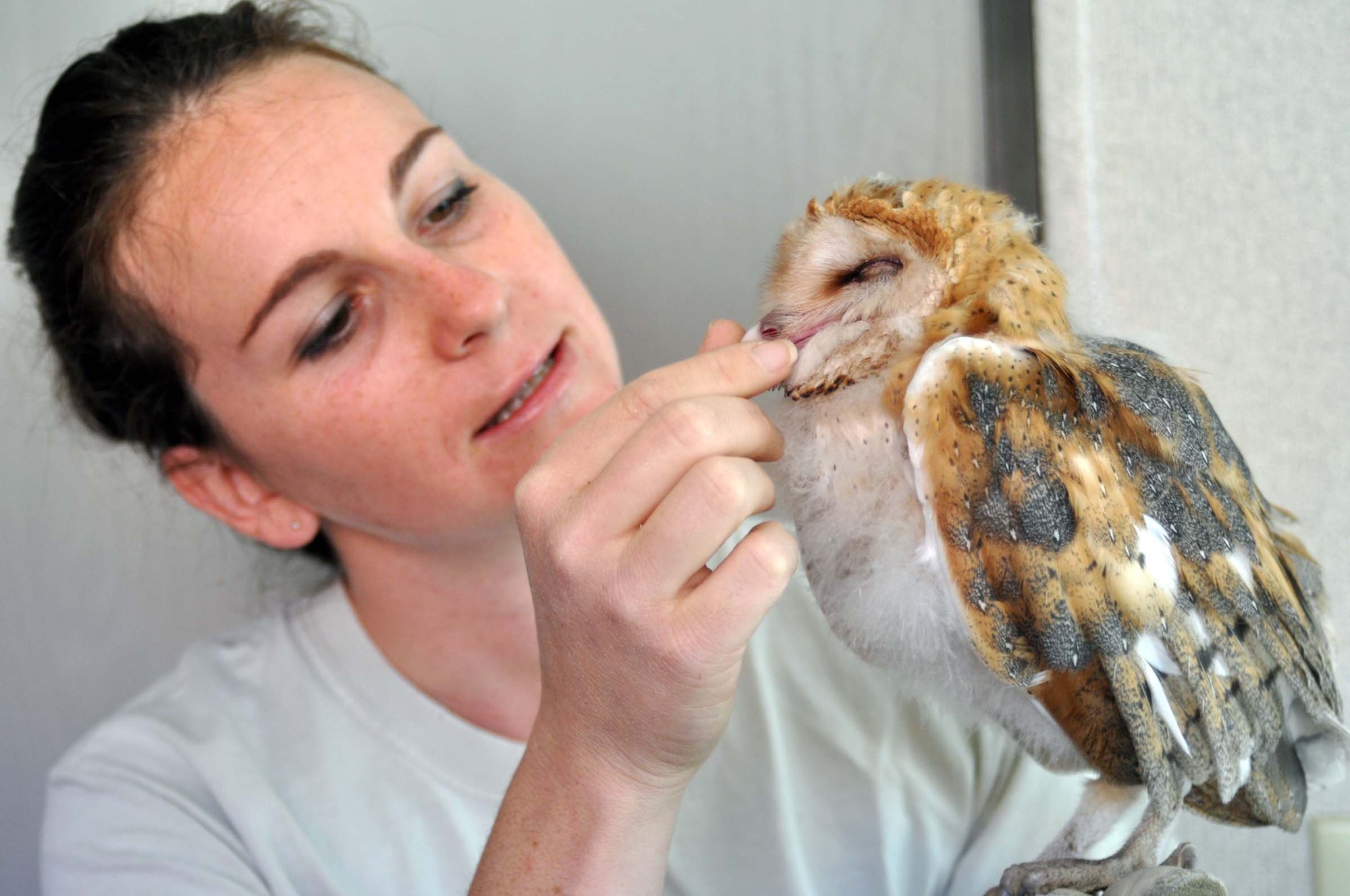 Rebecca Rosen, a wildlife control officer with Falcon Environmental Service, examines a two-month-old Barn Owl chick at March Air Reserve Base, Calif., June 1, 2011.  Col. Karl McGregor, 452nd Air Mobility Wing commander, rescued the disoriented chick from a street near his house just hours before.  (U.S. Air Force photo/Linda Welz)