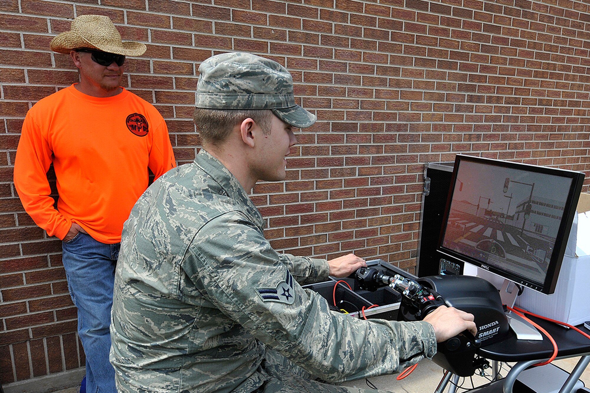 Airman 1st Class William Fields attempts to maneuver his simulated motorcycle in heavy city traffic while Dave Tolbert of the Motorcycle Training Academy observes. The Honda SMARTrainer is a traffic simulator specifically designed to give riders a safe bridge between a typical beginning riding course (which often take place in a parking lot) and the real-world scenario of riding in traffic and on public roads. The simulator was part of Motorcycle Safety Day June 2, 2011, on Peterson AFB, hosted by the 21st Space Wing Safety Office. All summer, the safety office will host special events to highlight the 101 Critical Days of Summer safety campaign. (U.S. Air Force photo/Rob Bussard)