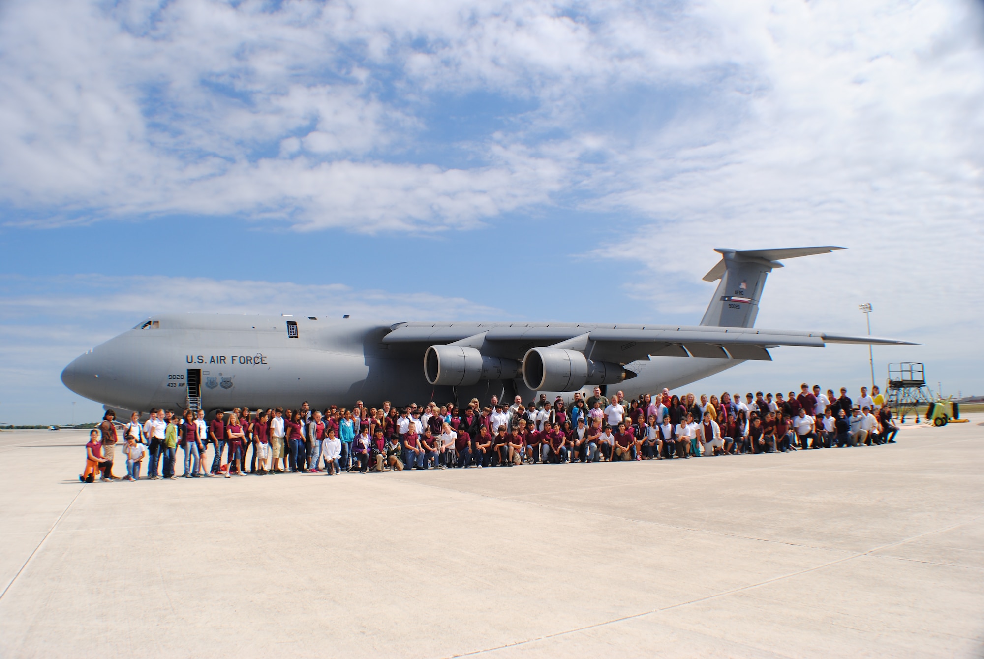 Back row center: Members of the 68th Airlift Squadron pose for a group photo with more than 120 students and their teachers from Devine Middle School minutes before beginning a tour of the C-5 Galaxy cargo jet in the background May 16, 2011 at Lackland Air Force Base, Texas. This recent field trip marks the thirteenth year in-a-row that the sixth graders from Devine, Texas, have visited the Alamo Wing. (U.S. Air Force photo/Senior Airman Luis Loza Gutierrez)