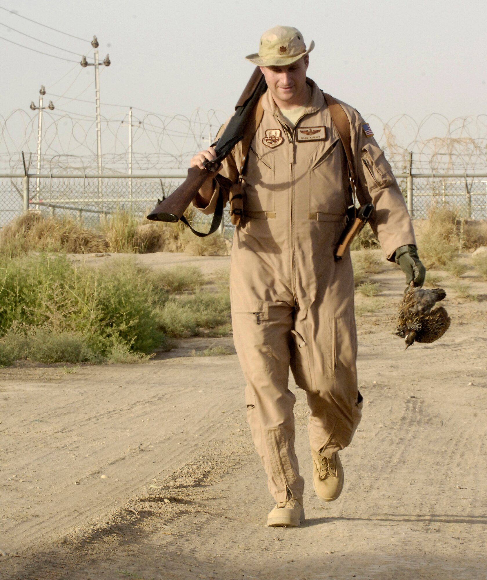 Maj. David Aumack brings in a quail he killed June 3, 2011, as part of the Bird/Wildlife Aircraft Strike Hazard program at Baghdad International Airport. The BASH program is designed to reduce wildlife hazards by keeping birds and other animals away from runways and planes. Major Aumack is a flight safety officer assigned to the 321st Air Expeditionary Wing. (U.S. Air Force photo/Tech. Sgt. Randy Redman)