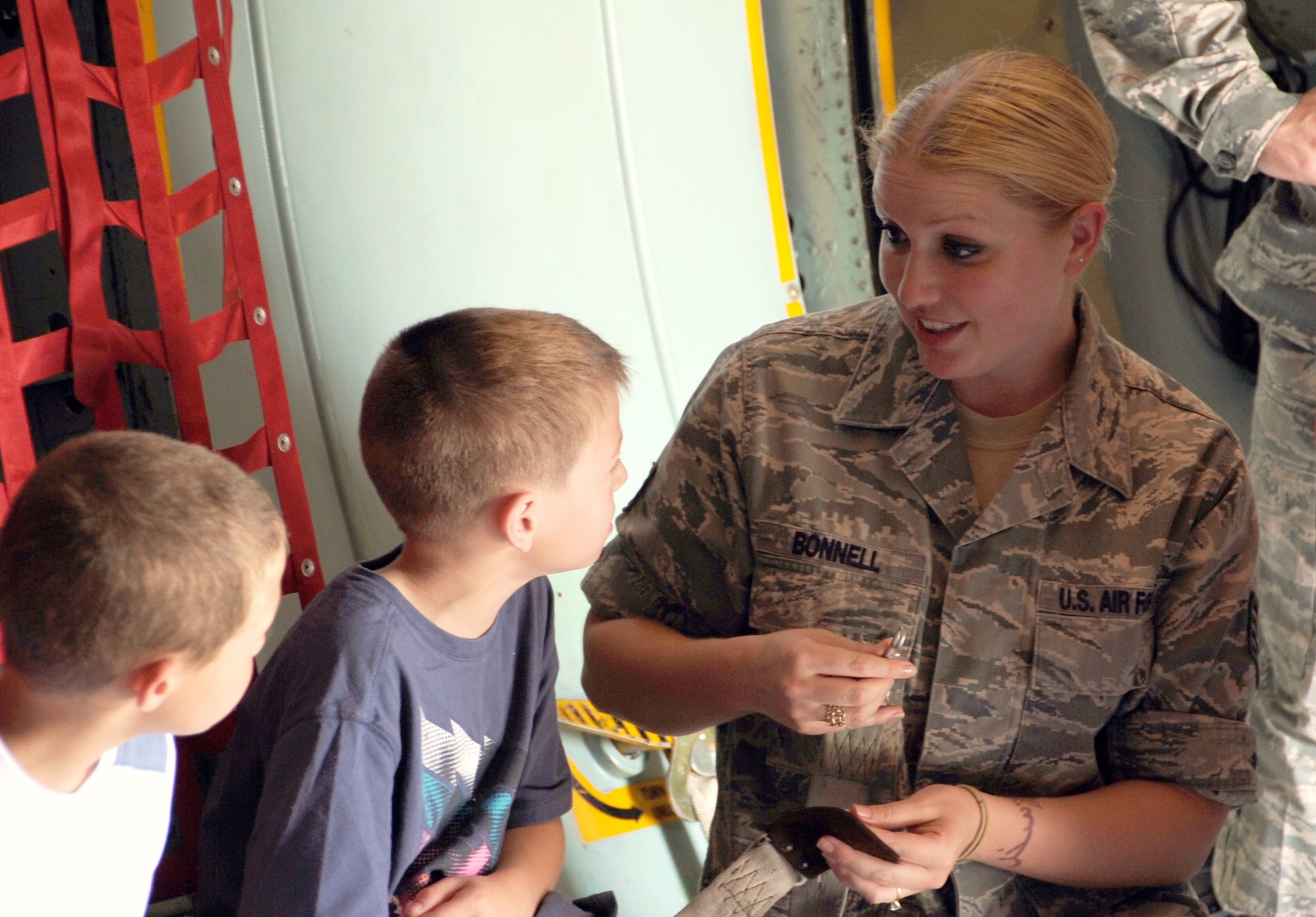 Staff Sgt. Cheven Bonnell, 87th Medical Operations Squadron physical therapist technician, explains how to fasten a seatbelt to a child she mentors on the C-141B Starlifter May 31. Bonnell has been mentoring local children with academics, social skills and overall progression in maturity for more than a year. (U.S. Air Force photo by Airman 1st Class Dennis Sloan/Released)
